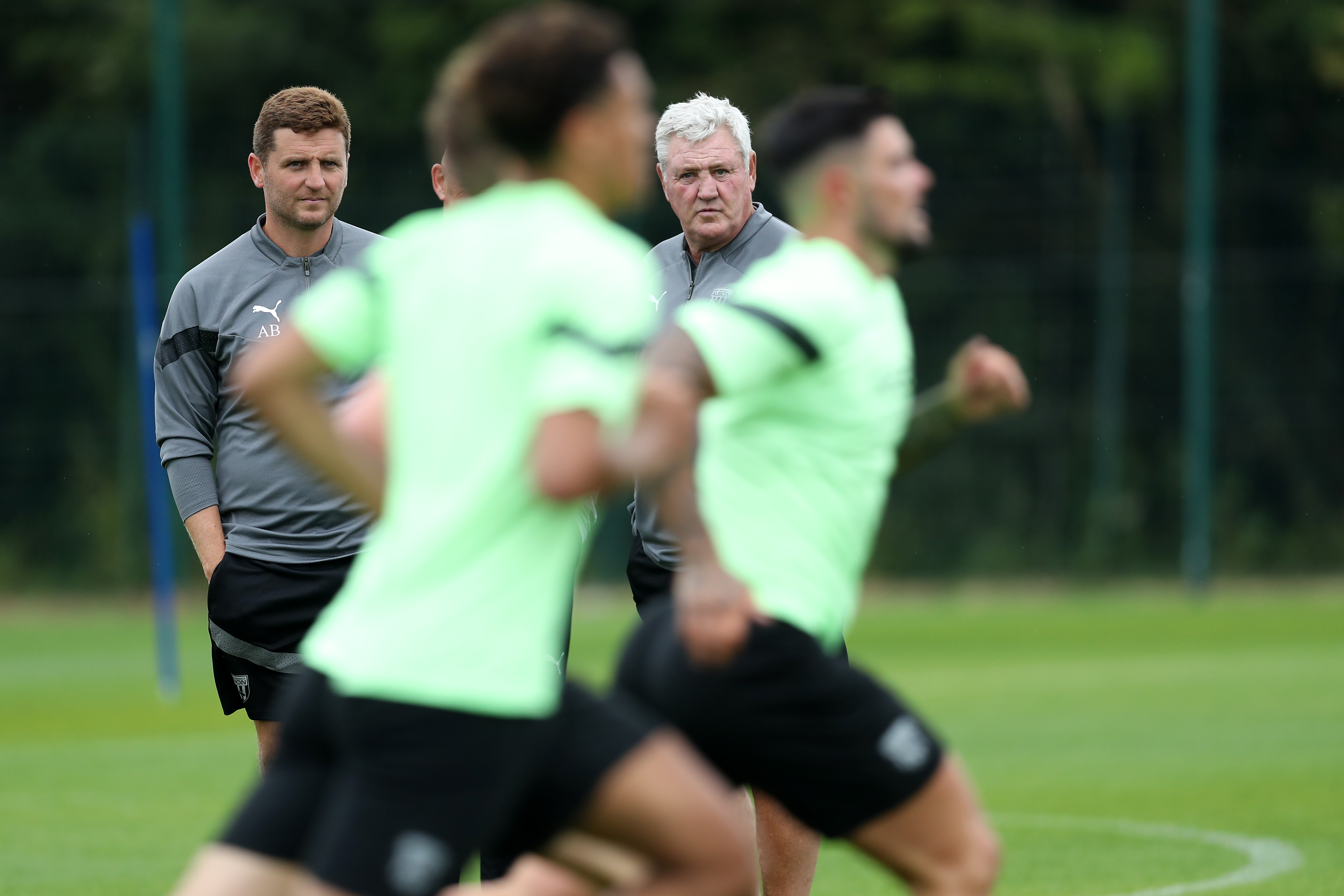 Albion players train as Steve Bruce looks on.