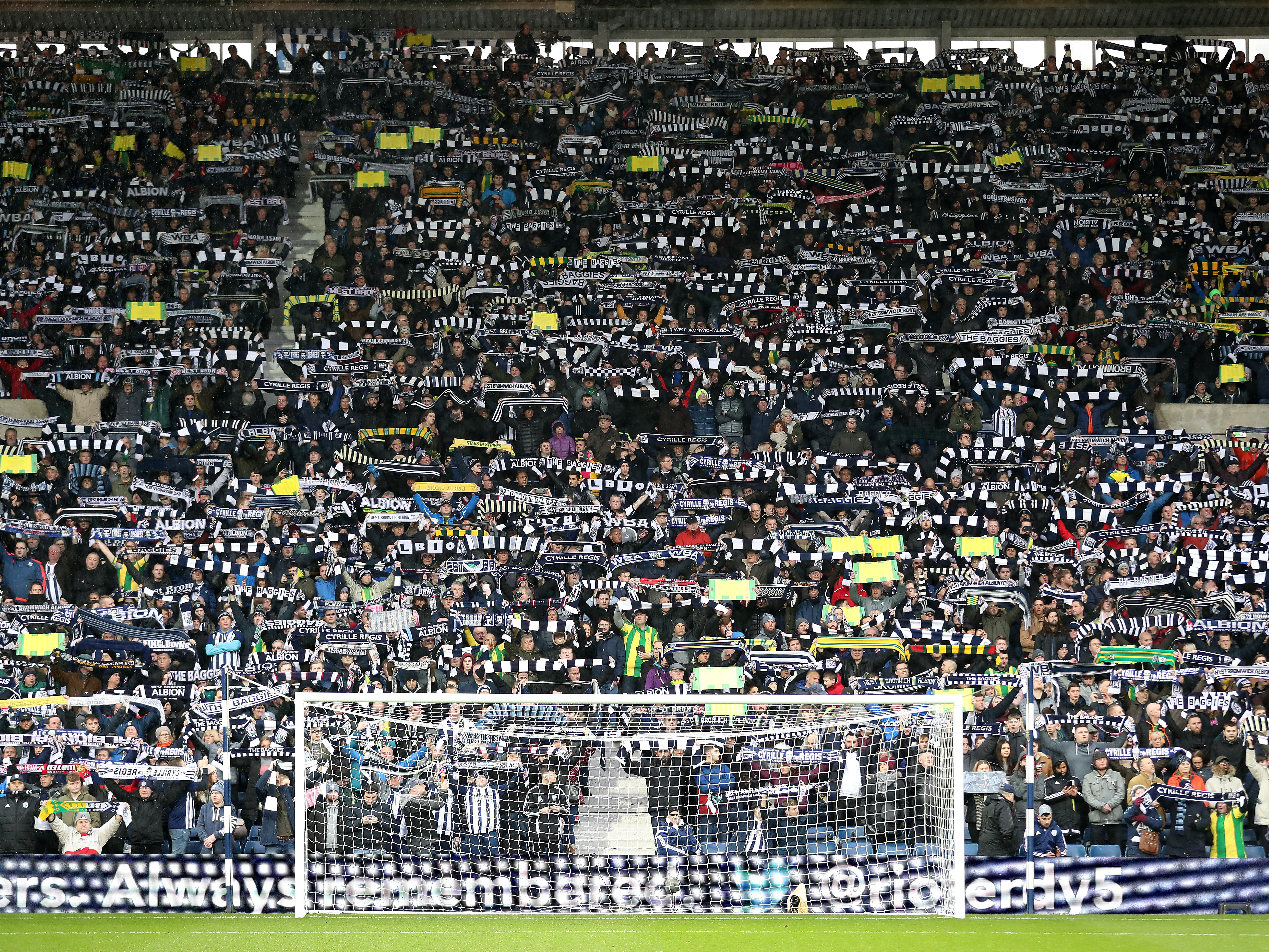 An image of Albion supporters raising their scarfs in the Birmingham Road End
