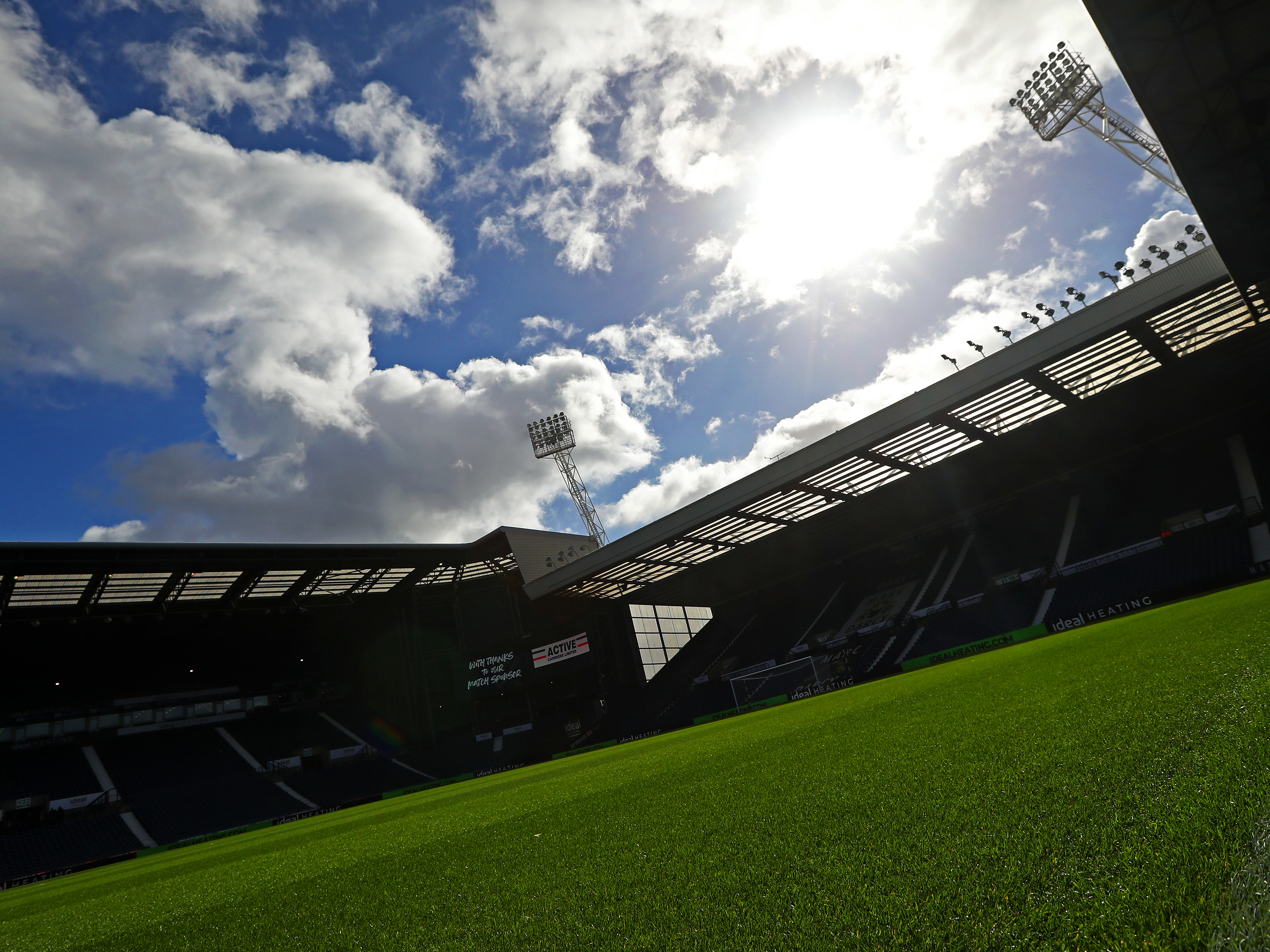 An image of The Hawthorns, surrounded by the sun breaking through some cloud