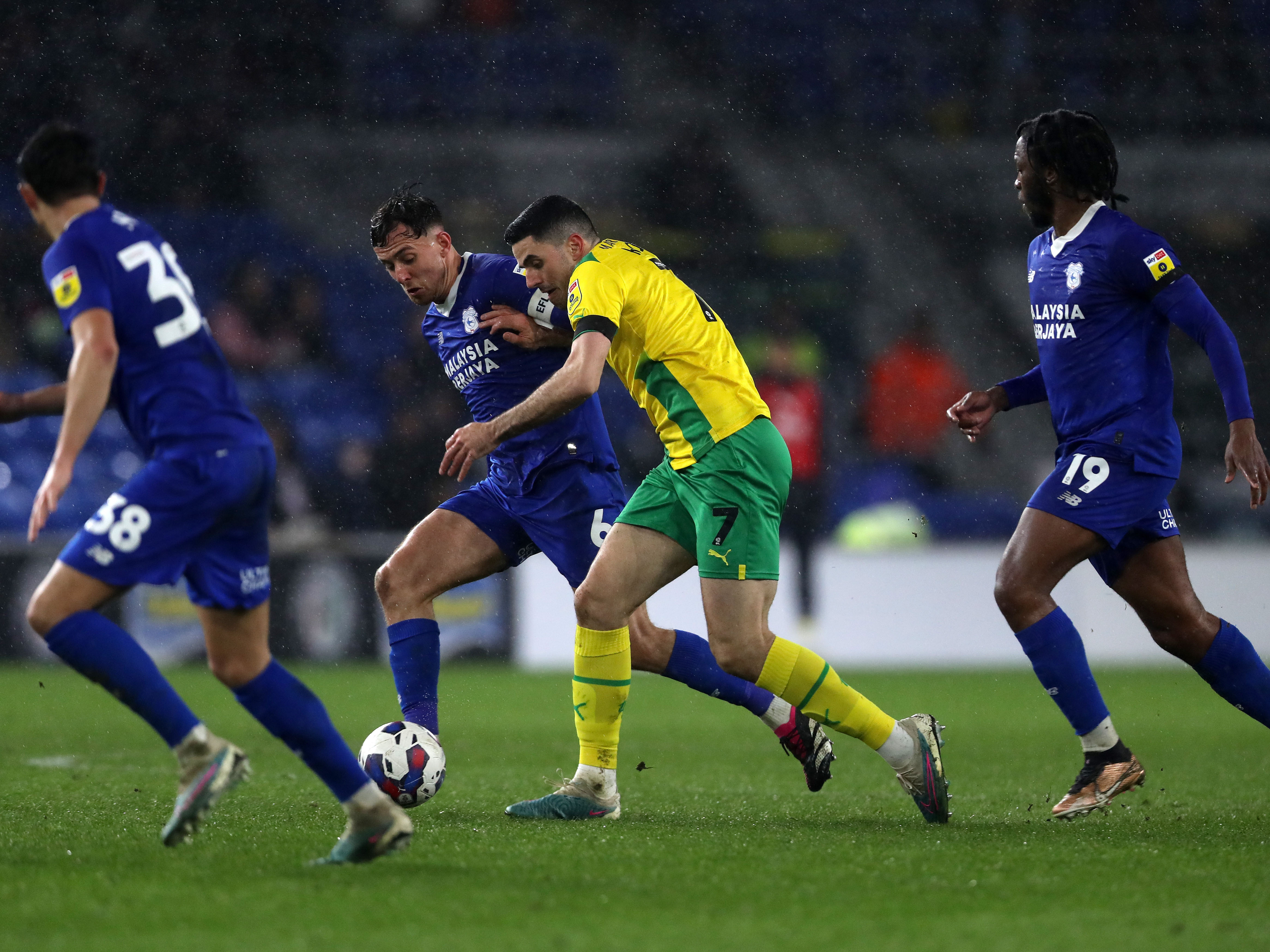 Tom Rogic holds off three Cardiff players
