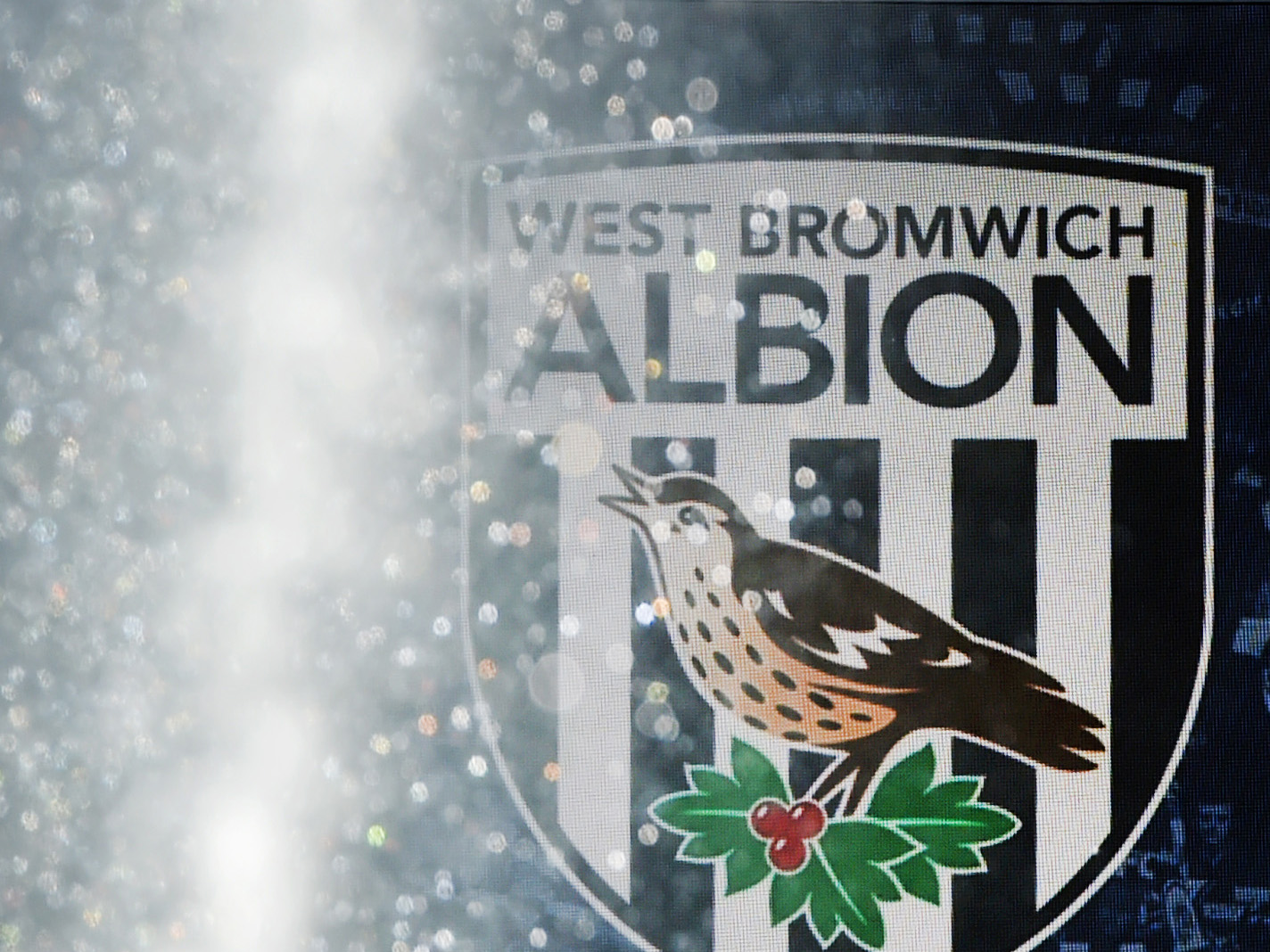 A sprinkler firing out water with a WBA badge in the background 