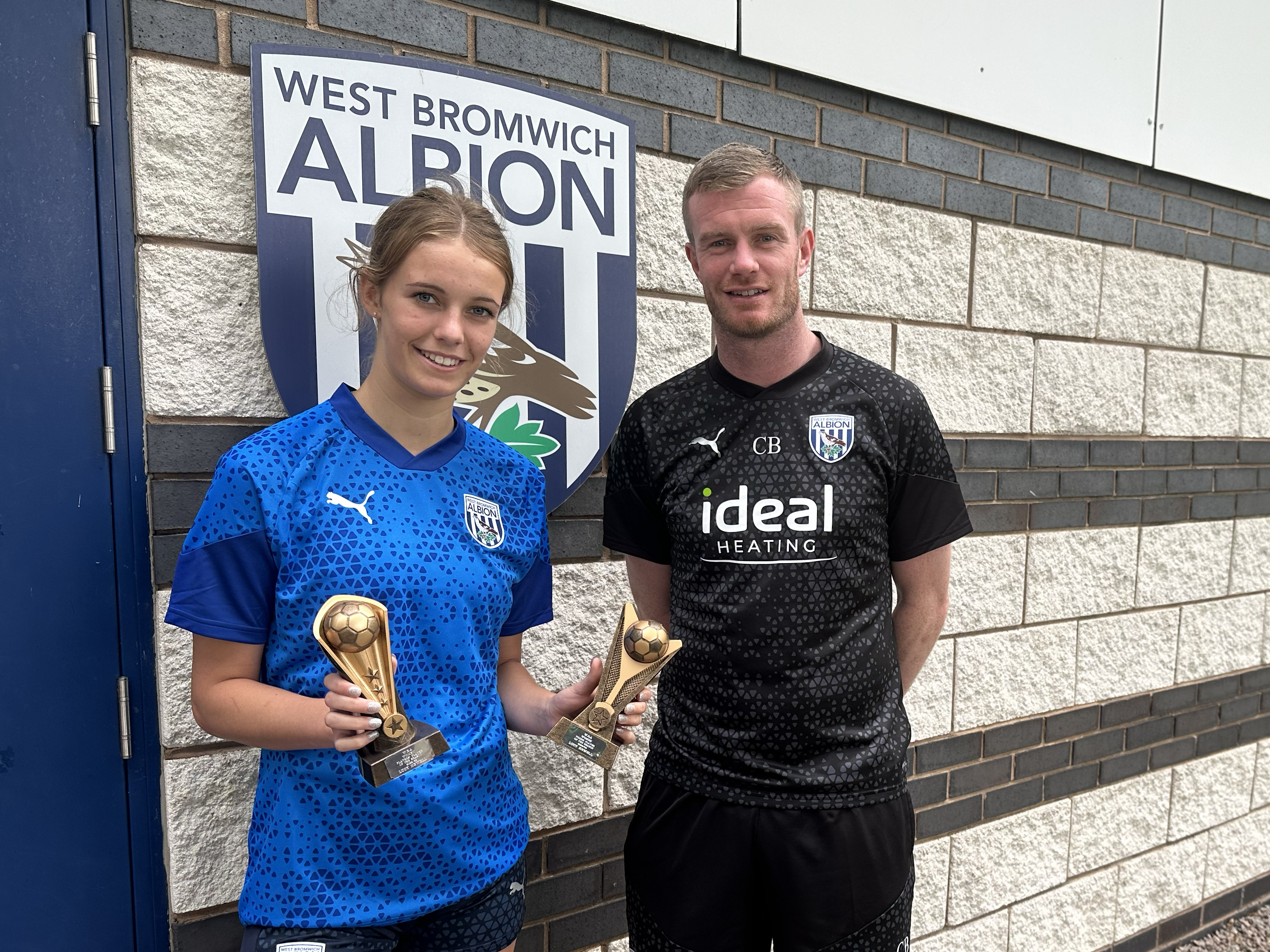 An image of Lucy Newell picking up her end of season awards, presented by club legend Chris Brunt