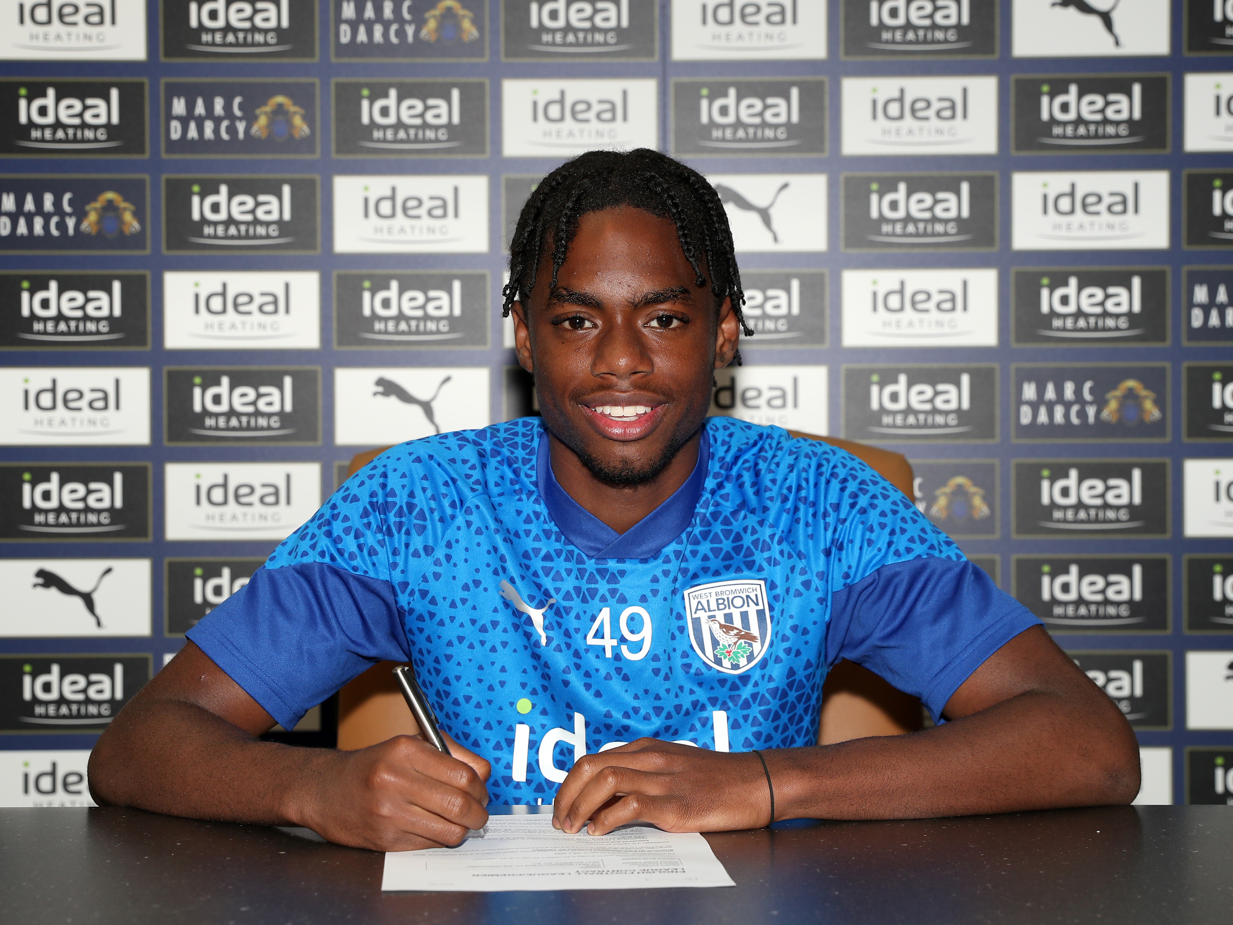 A photo of Akeel Higgins signing his first professional contract with Albion