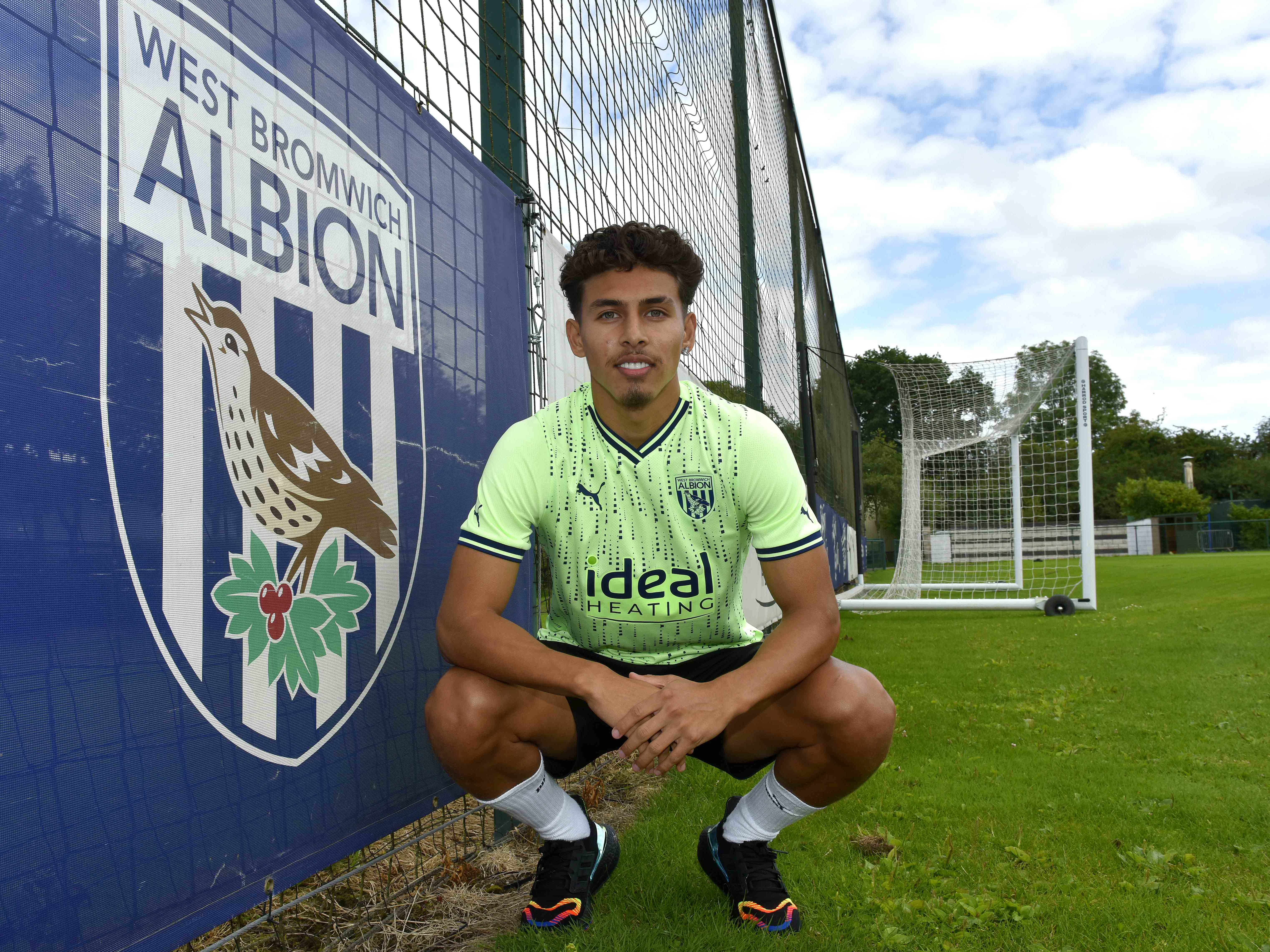 Jeremy Sarmiento kneels down by an Albion badge on the training pitch