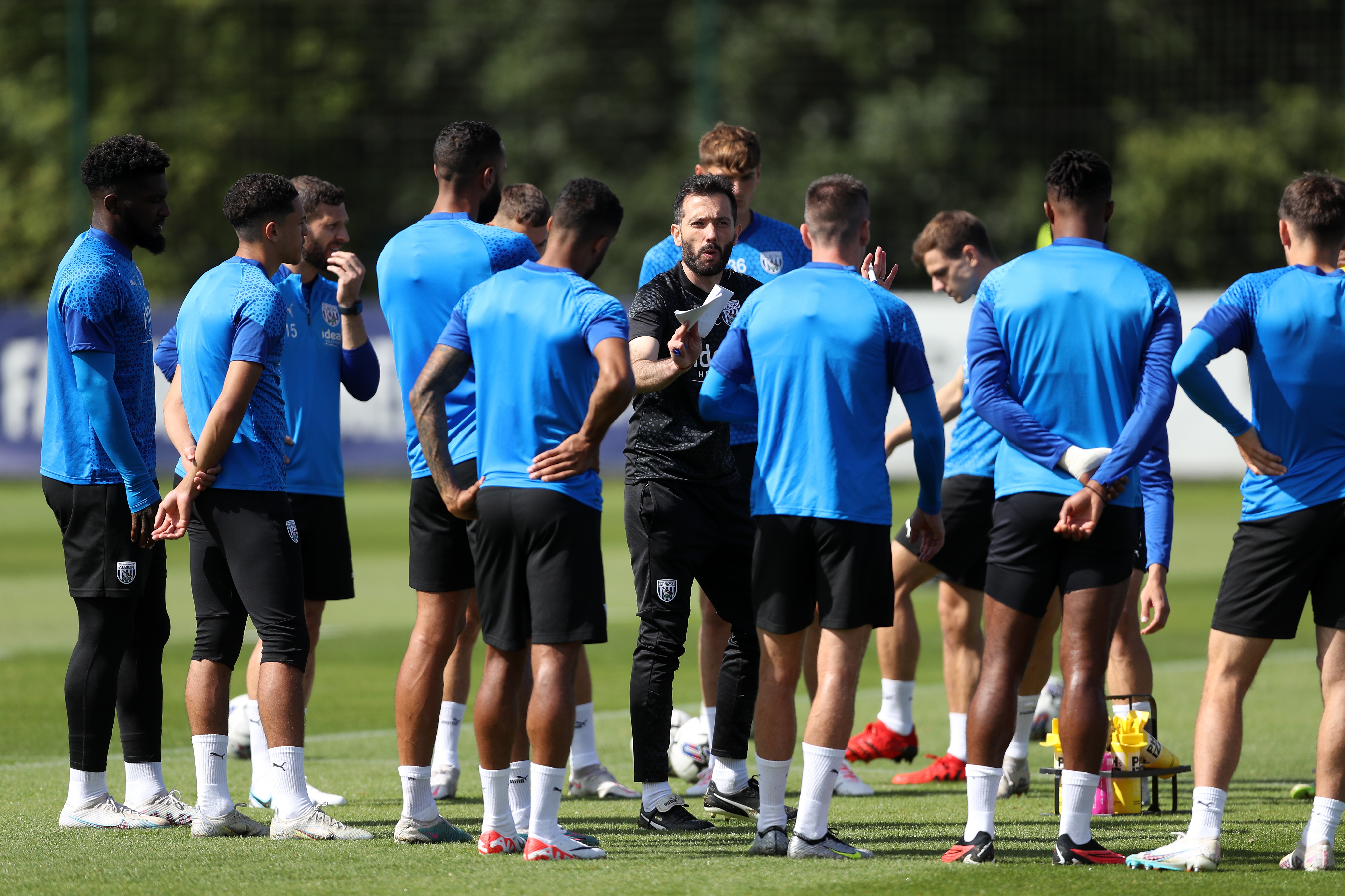 Carlos Corberán talking to a group of Albion players in training 