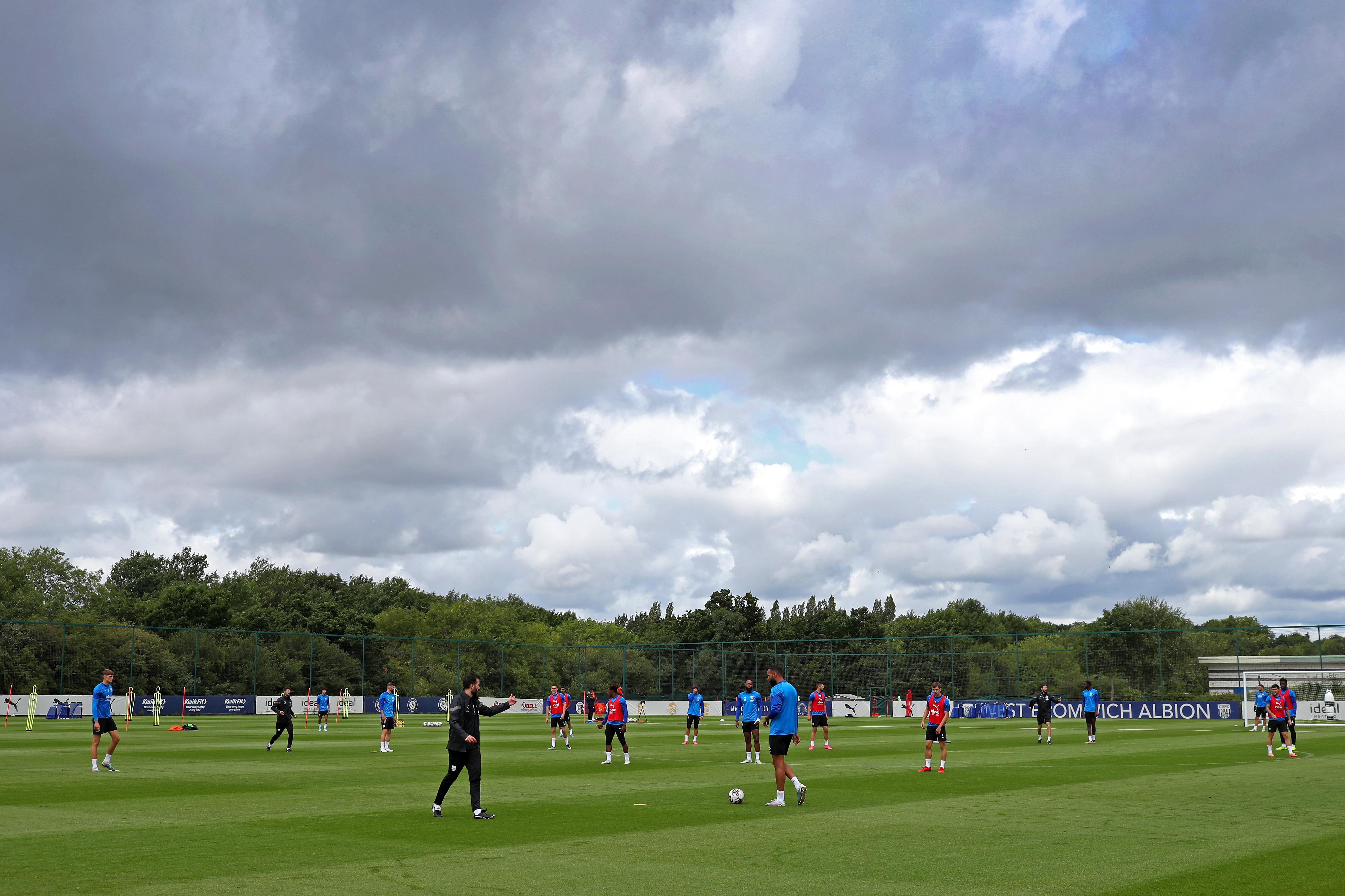A wide angle of the training pitch with several players in the background