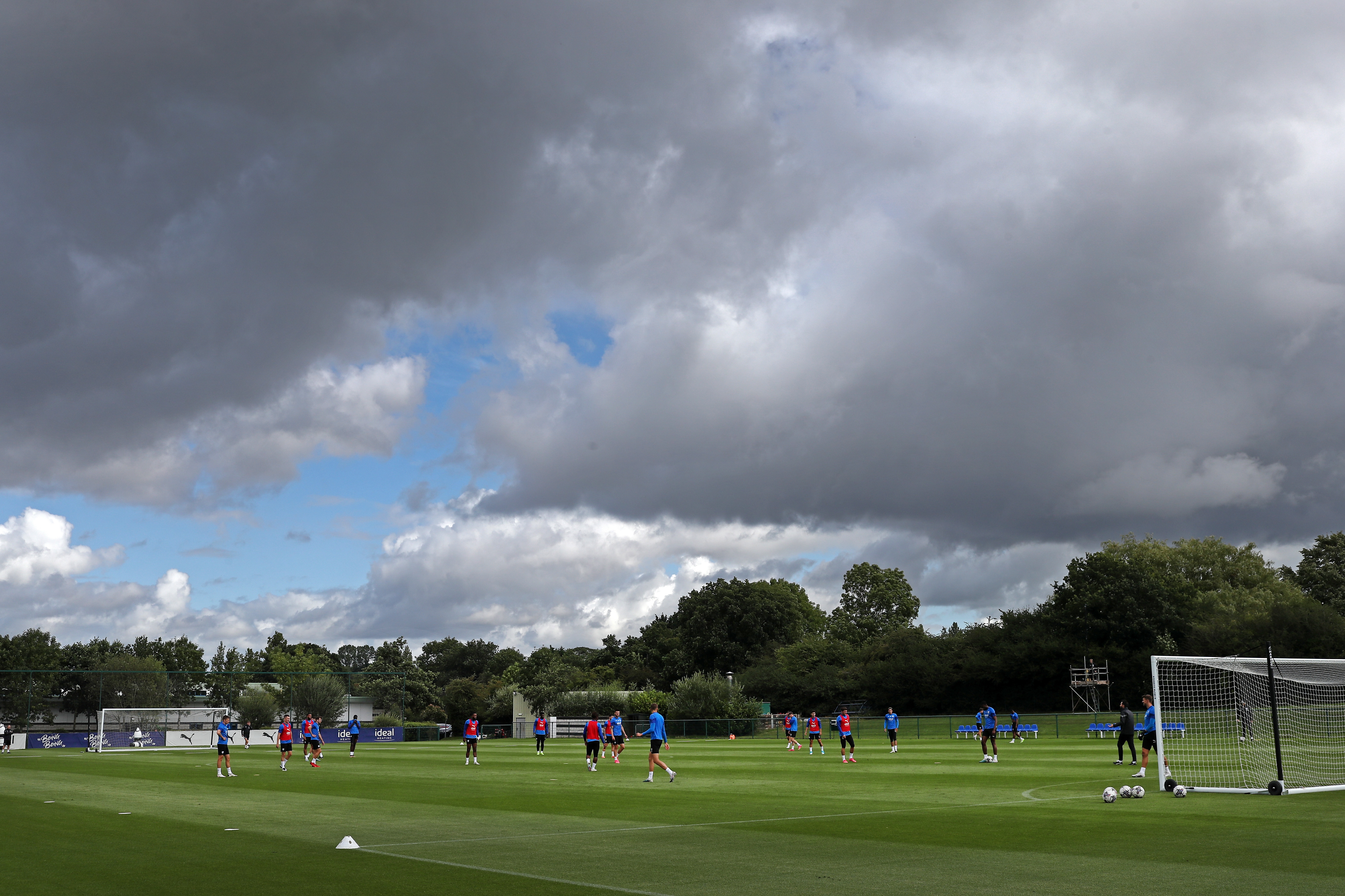 A wide angle of the training pitch with several players in the background