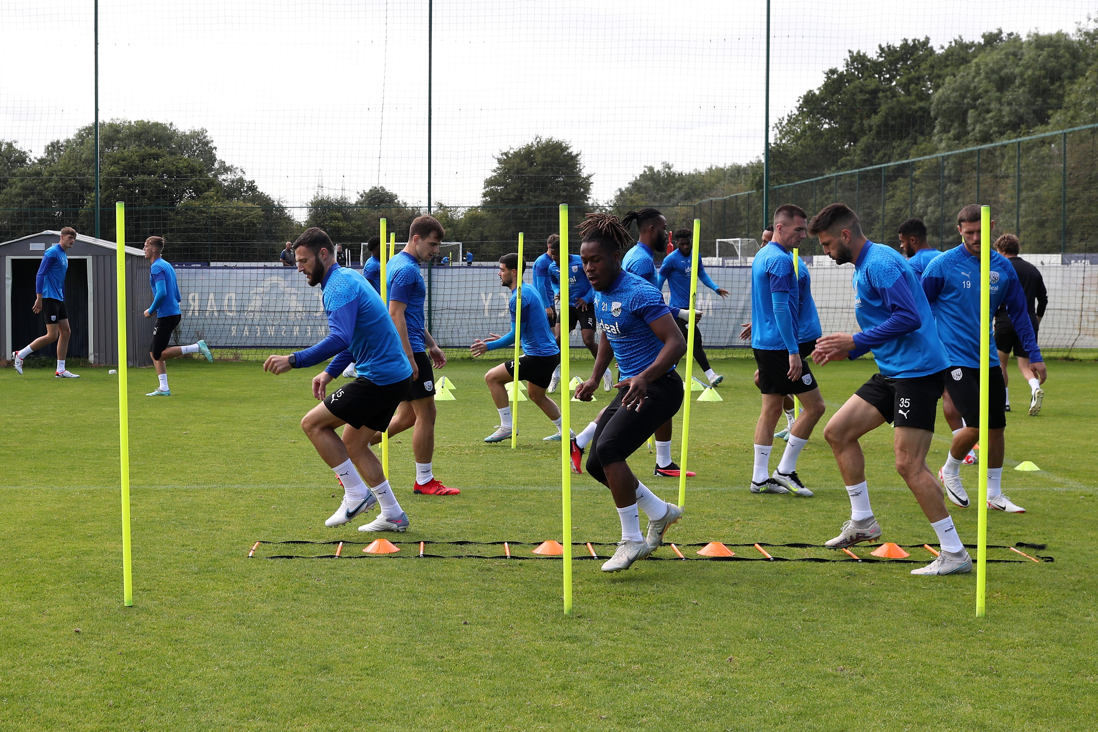 Albion players run through poles during the warm-up in training 