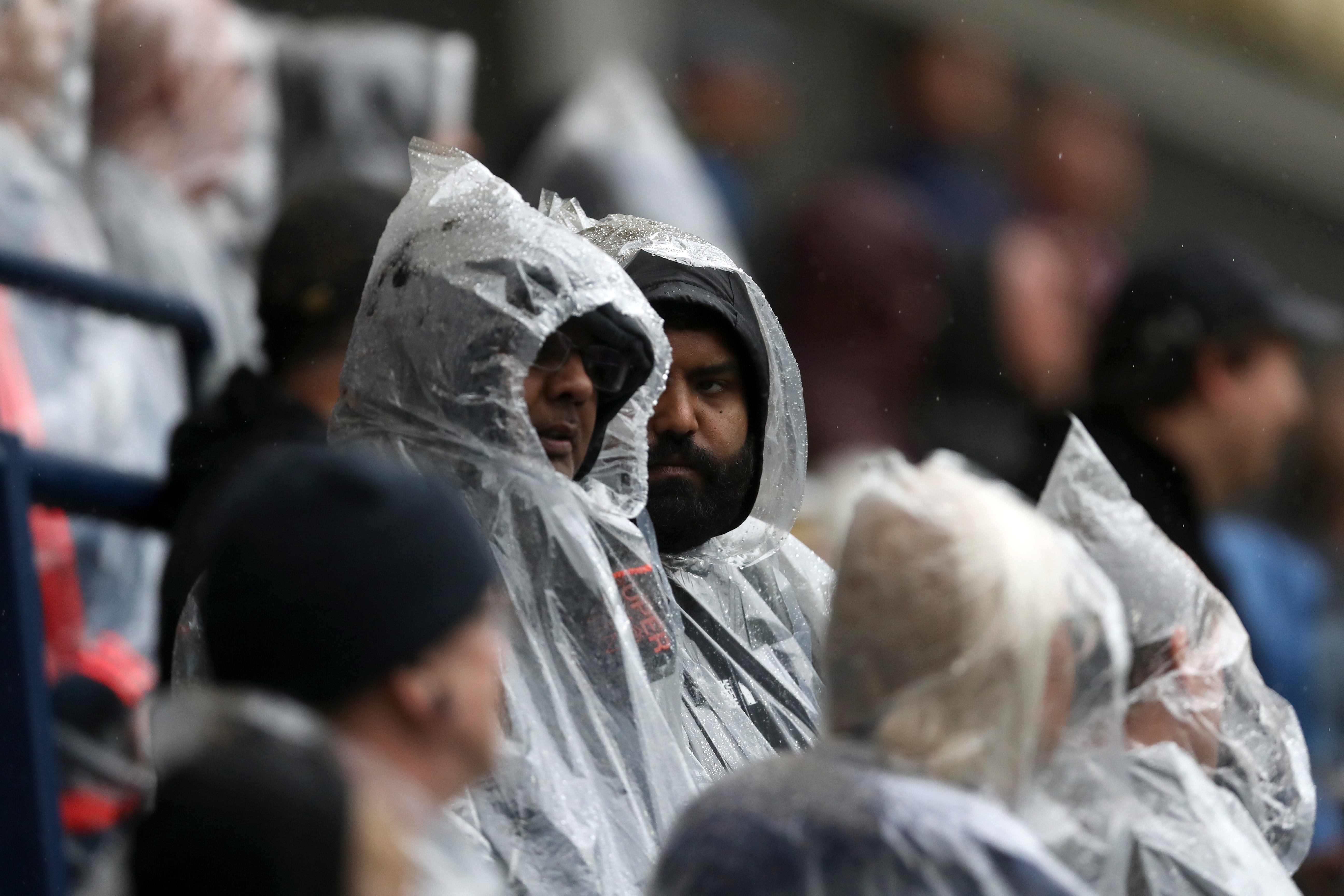 Two Albion fans stood in raincoats