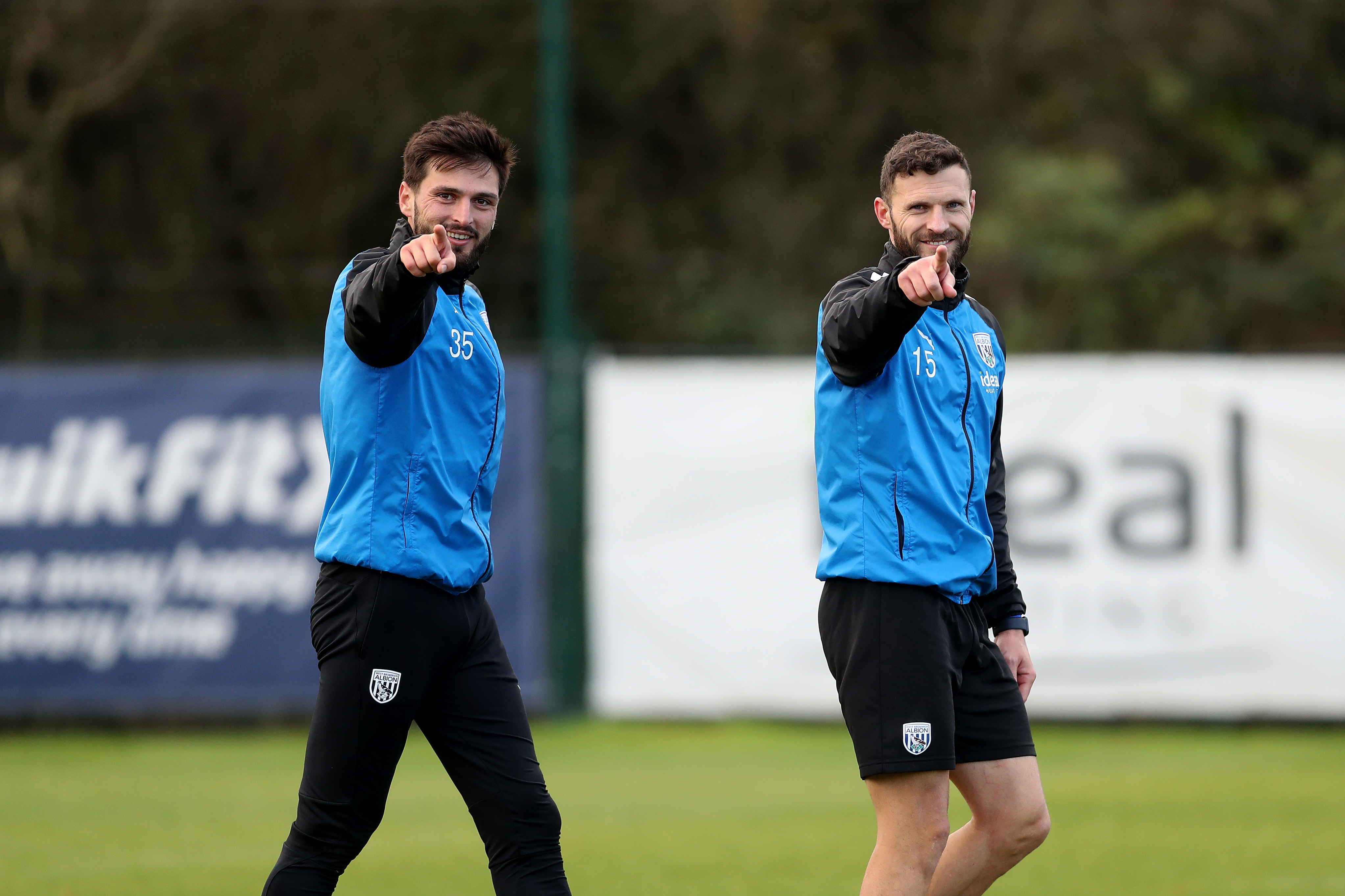 Okay Yokuslu and Erik Pieters pointing and smiling directly towards the camera