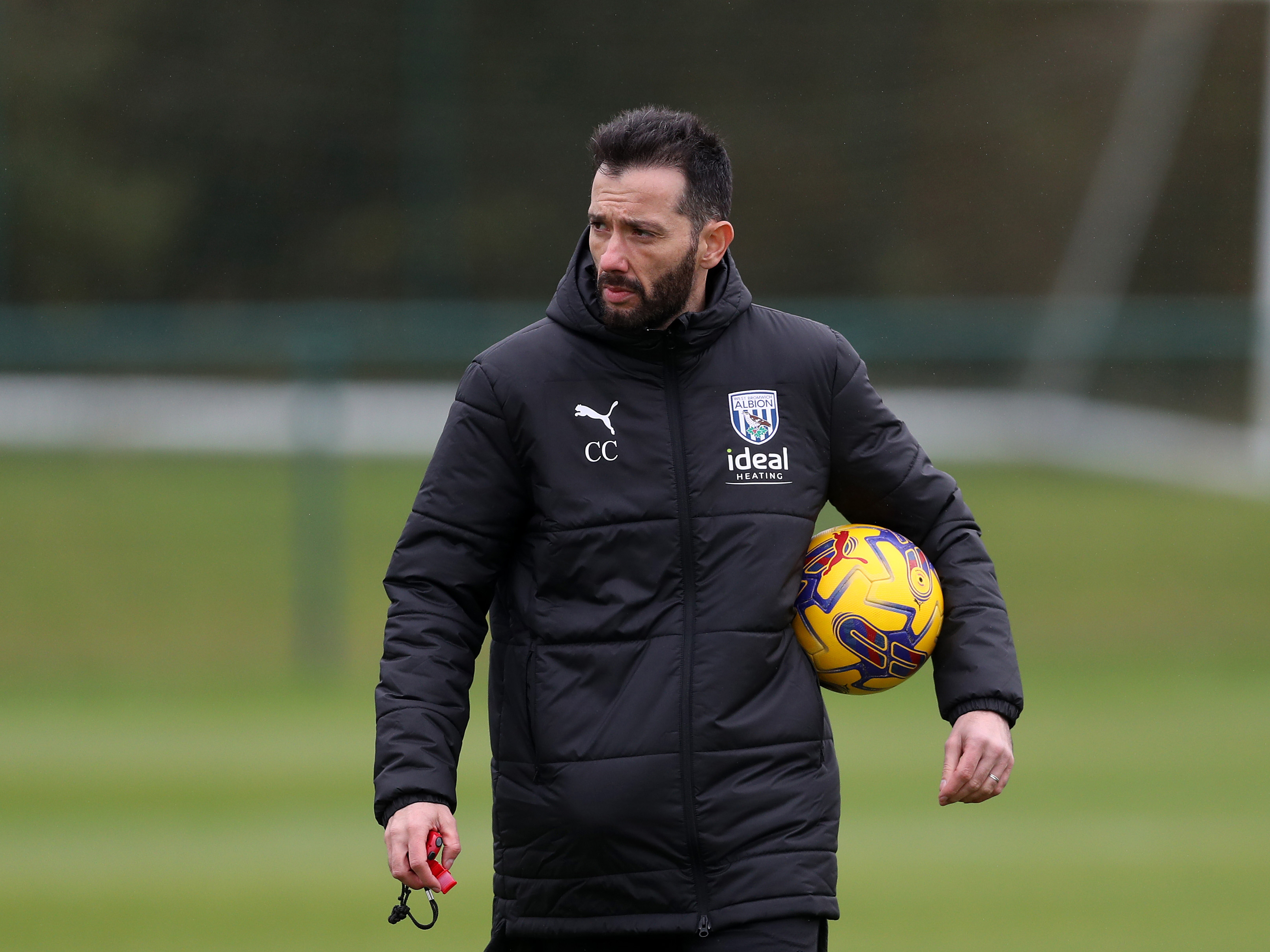 Carlos Corberán holding a yellow football during a training session