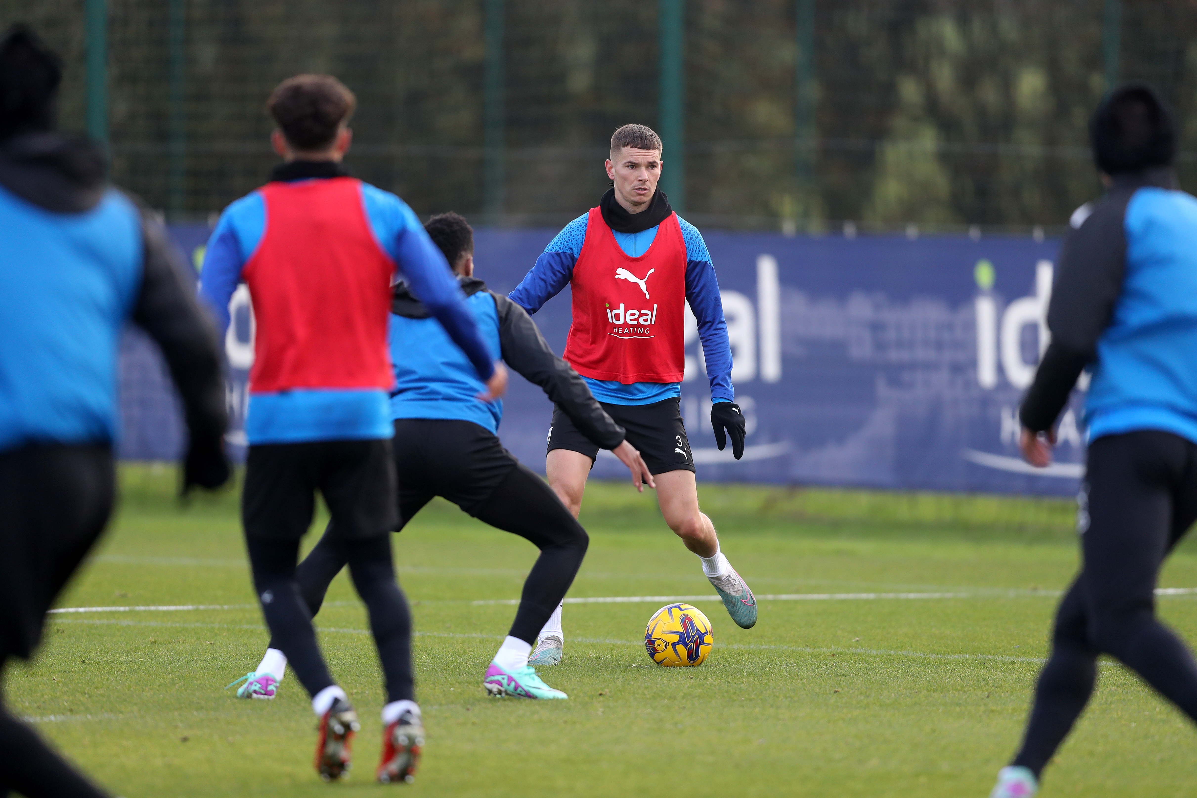 Conor Townsend on the ball in training while wearing a red bib