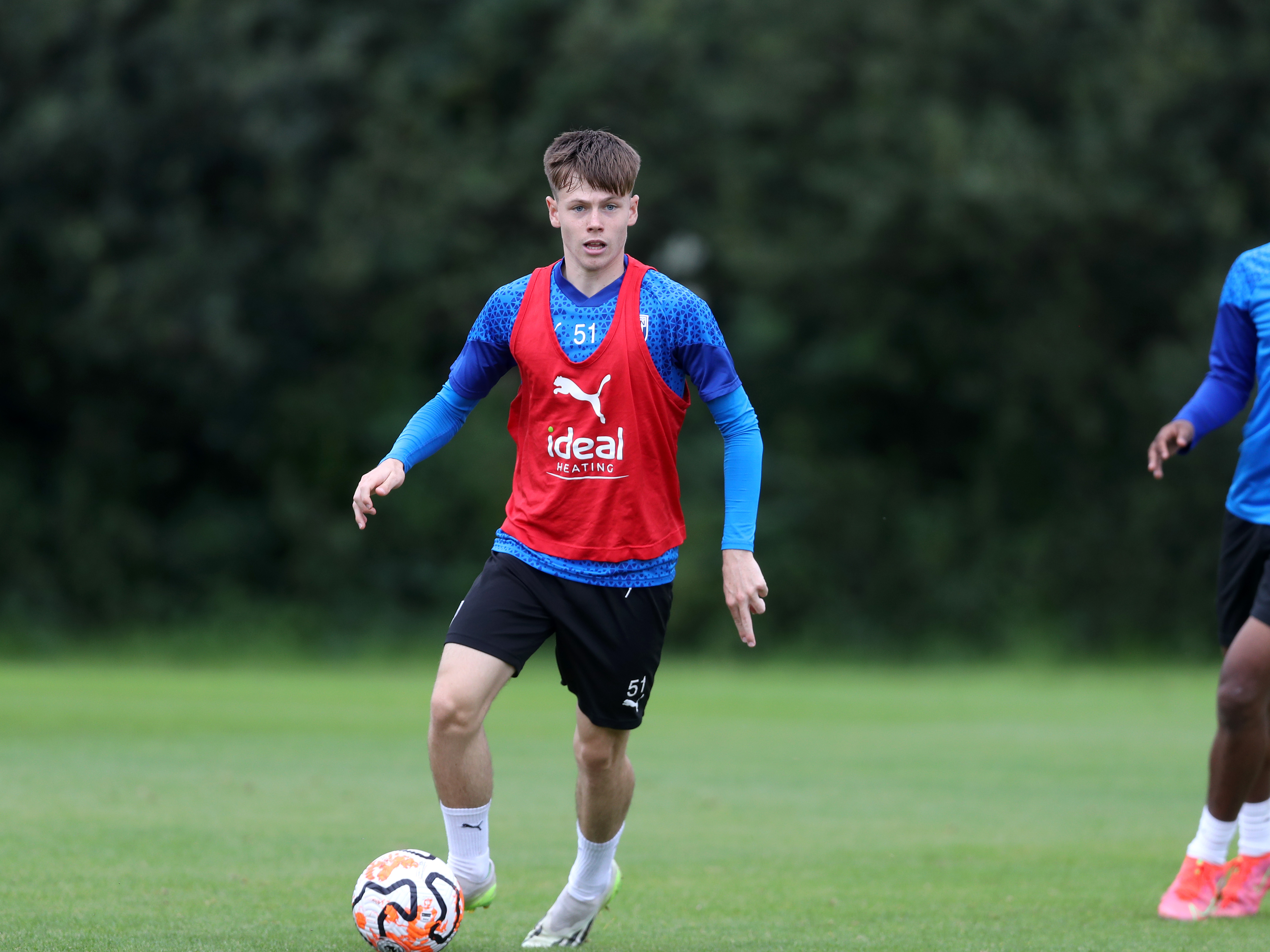 A photo of Albion U21s midfielder Fenton Heard on the ball, in the blue 2023/24 training wear, at the club's Walsall training ground pitches