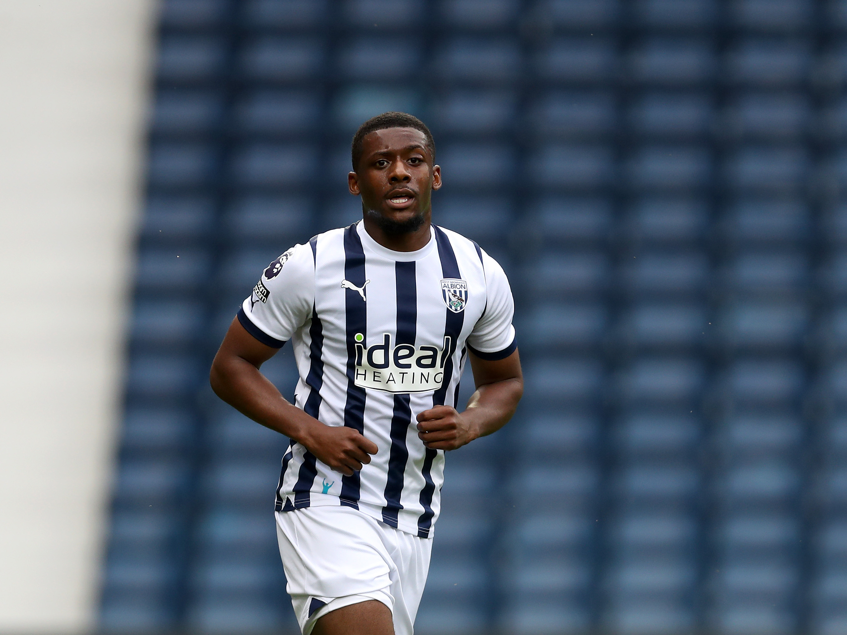 A photo of Jovan Malcolm, in the 2023/24 home kit, playing for Albion's Pl2 side at The Hawthorns