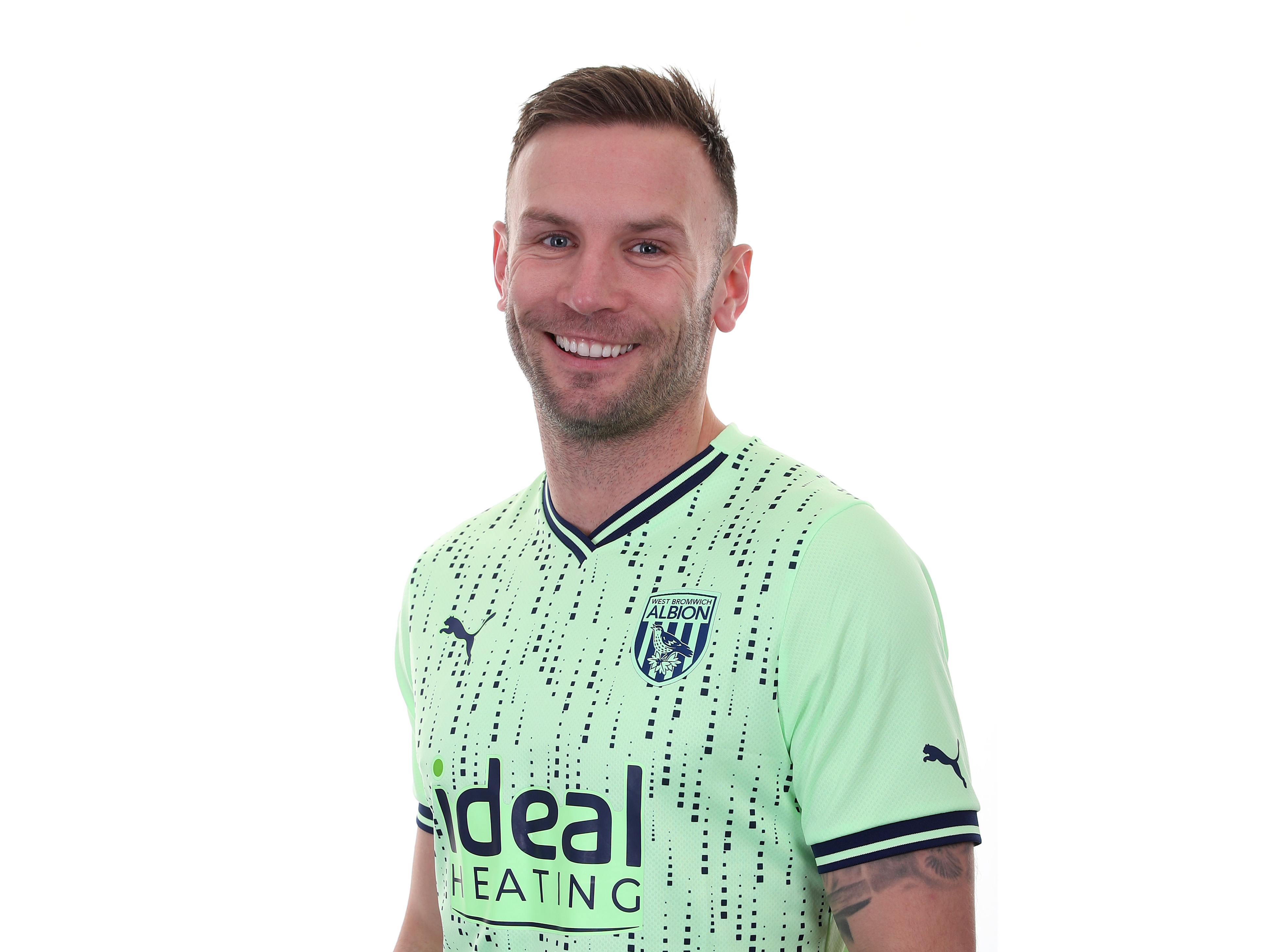 Andi Weimann smiling at the camera in the lime green away kit