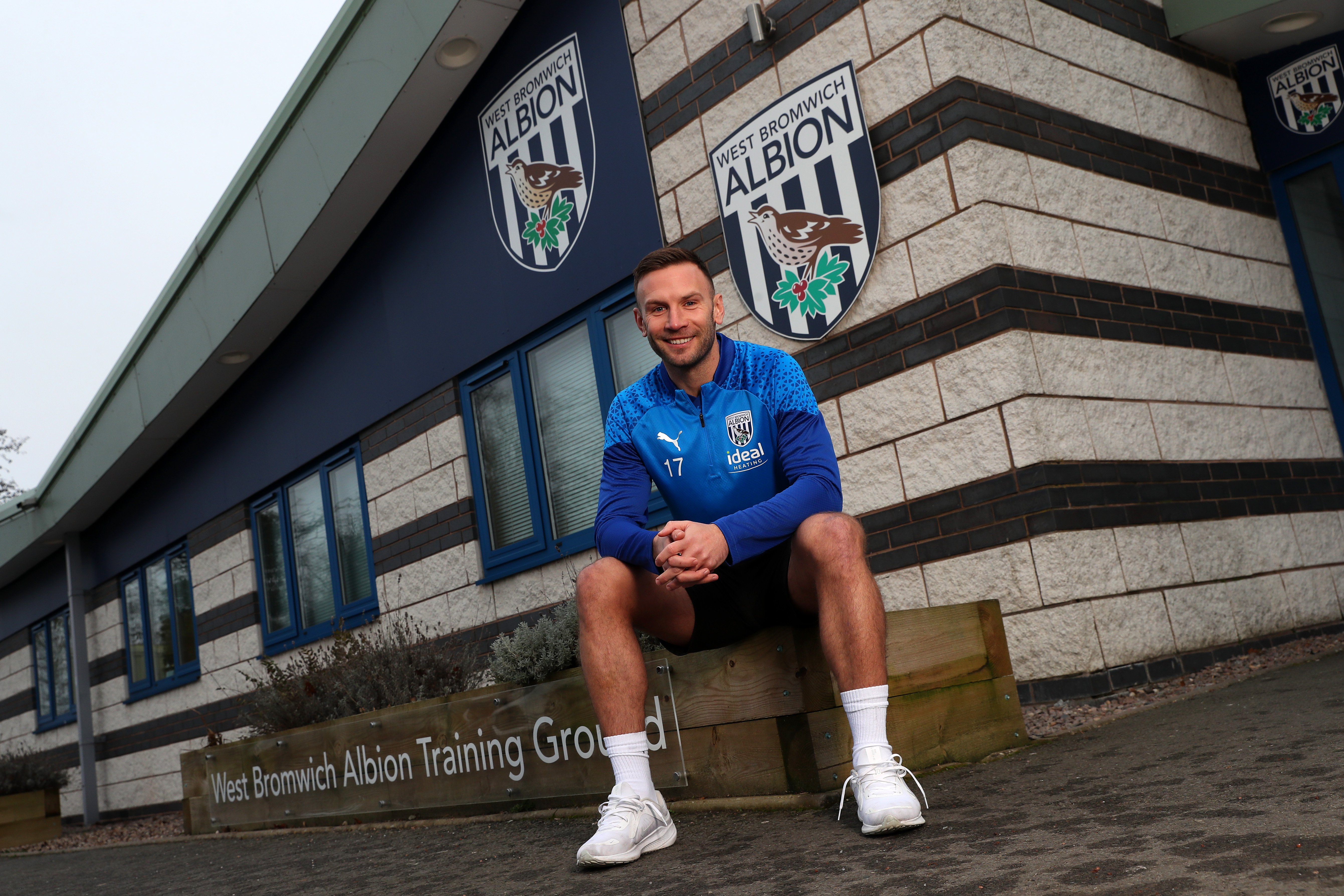 Andi Weimann smiling at the camera while sat outside the training ground