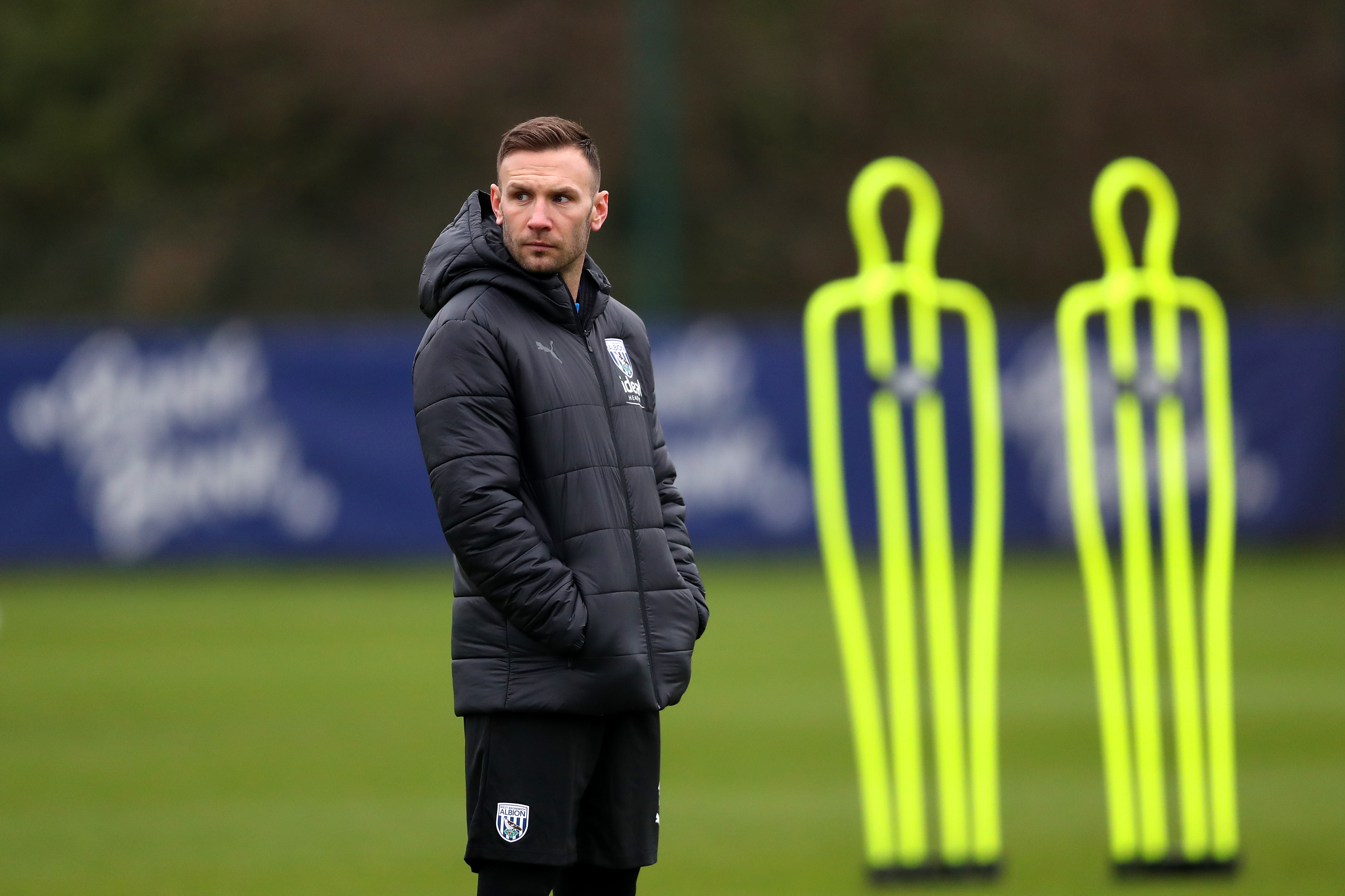 Andi Weimann watching training in a black coat