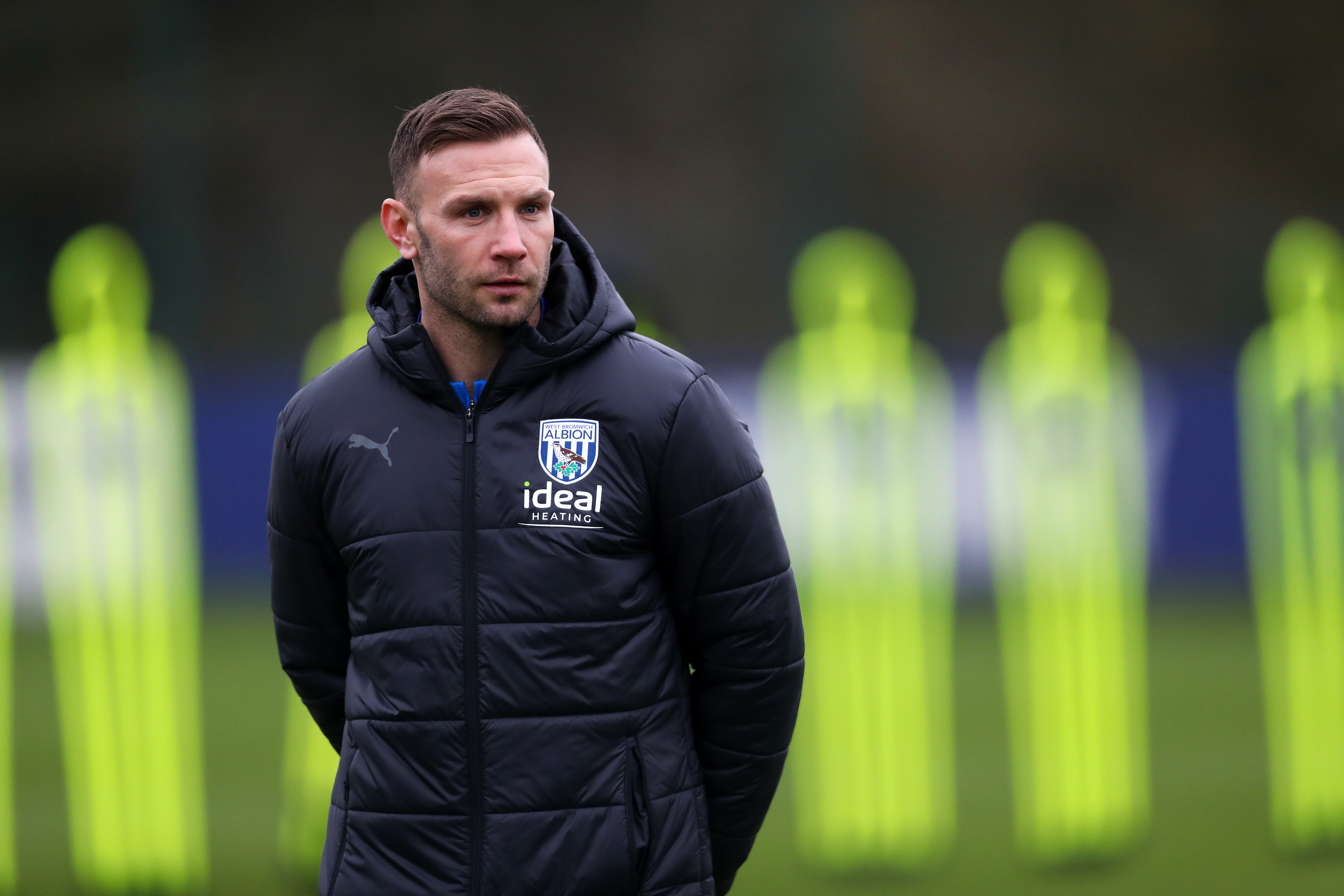 Andi Weimann watching training in a black coat
