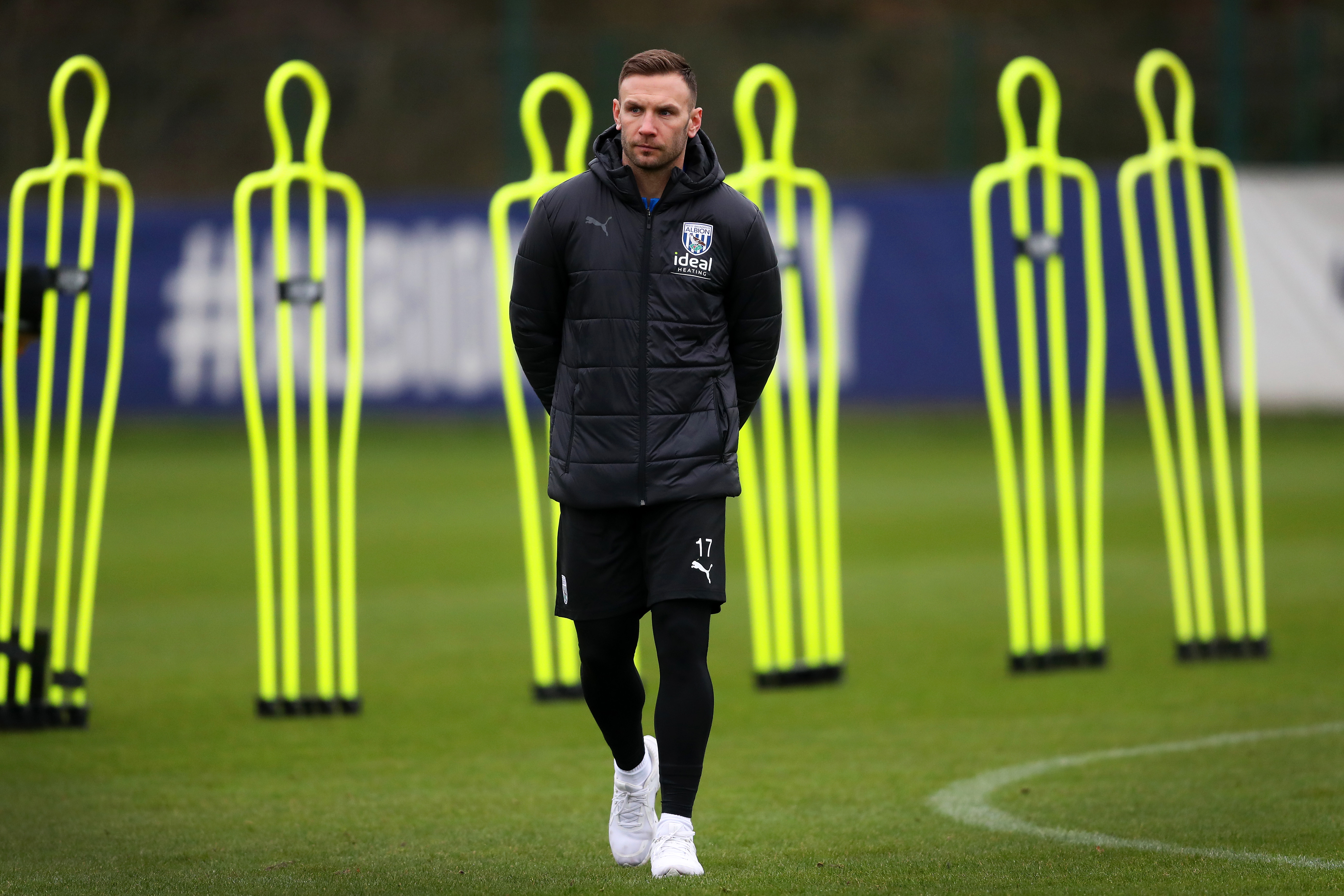 Andi Weimann watching training in a black coat