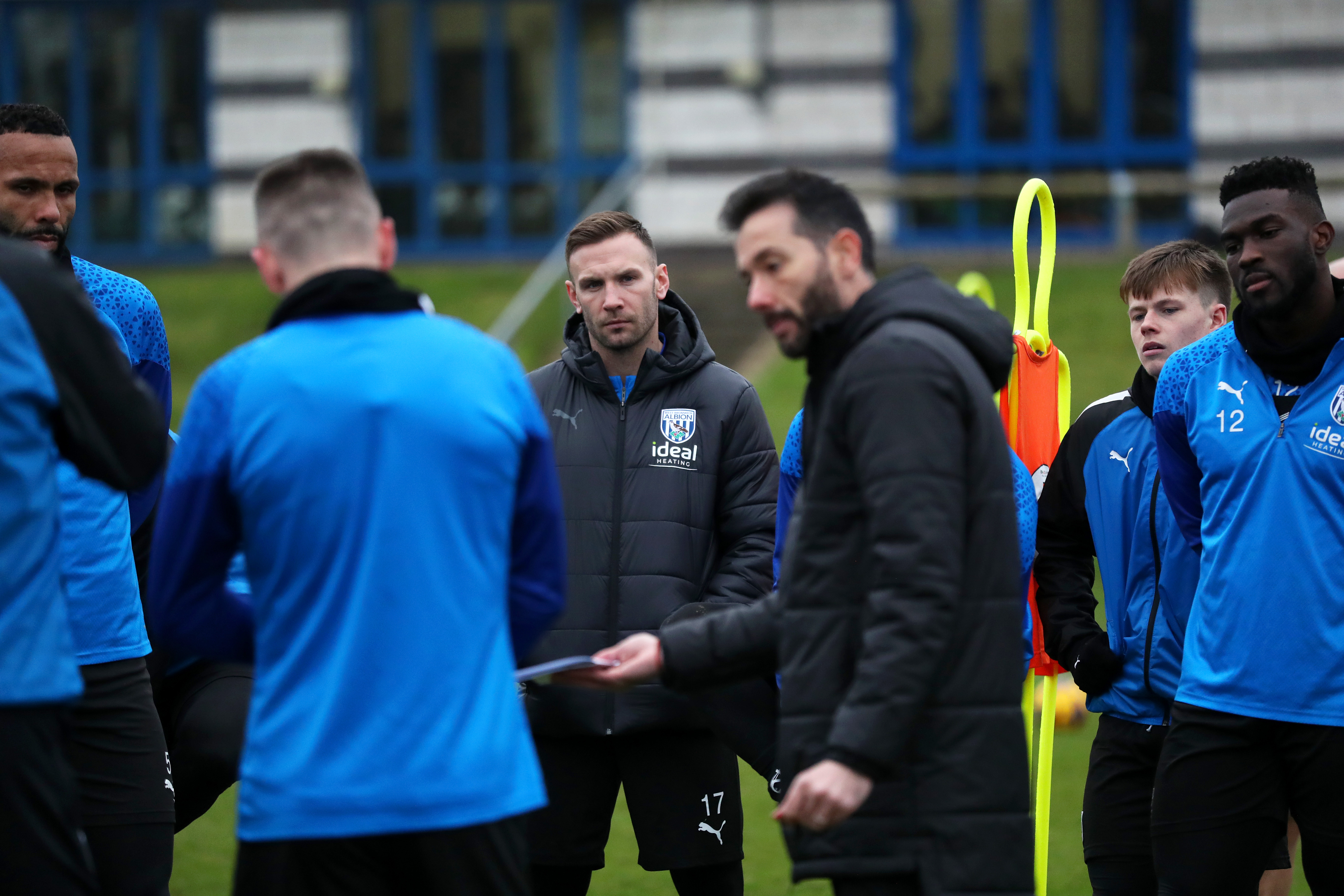 Andi Weimann watching Carlos Corberán deliver a speech during a training session