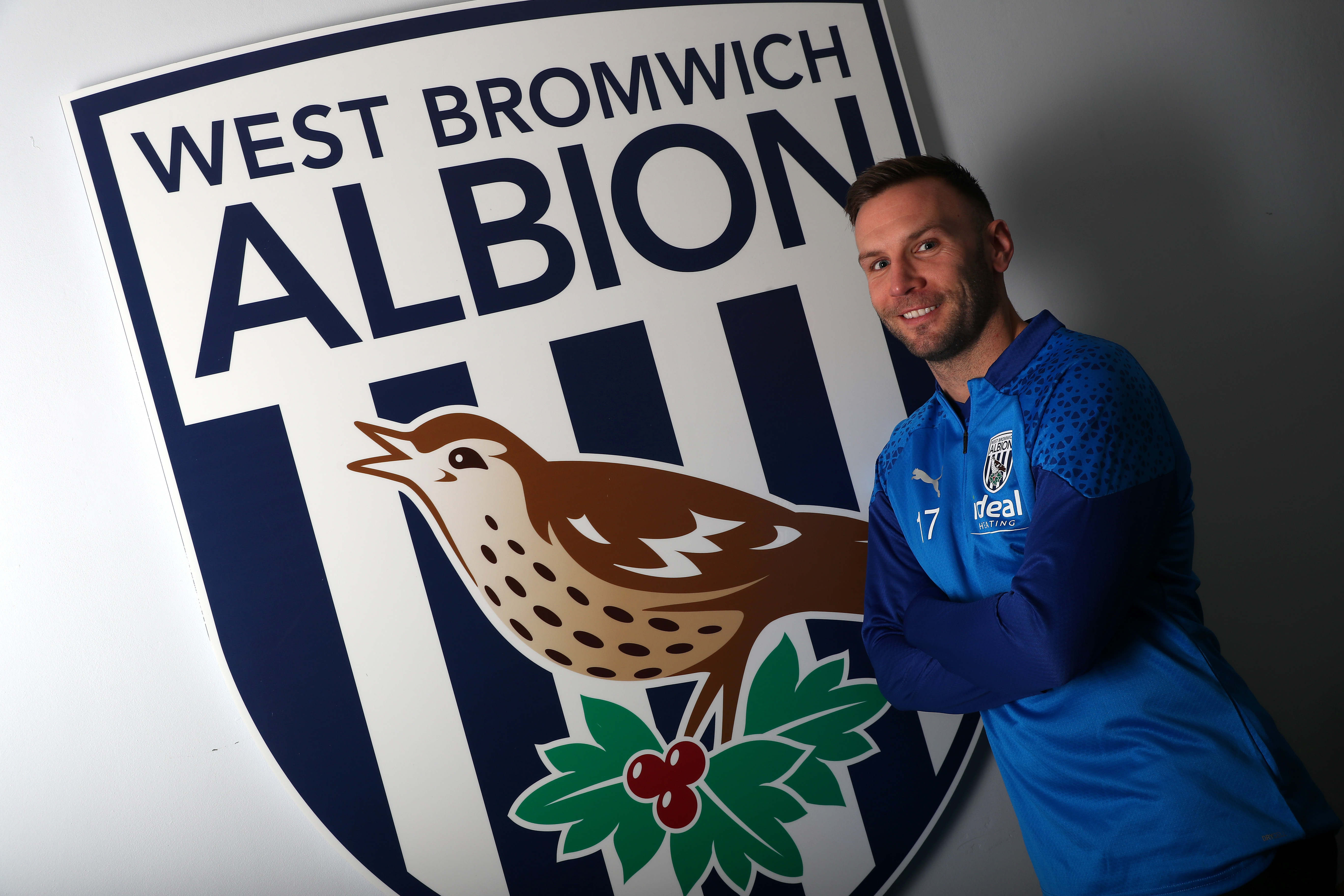 Andi Weimann posing for a photo standing next to a big WBA badge