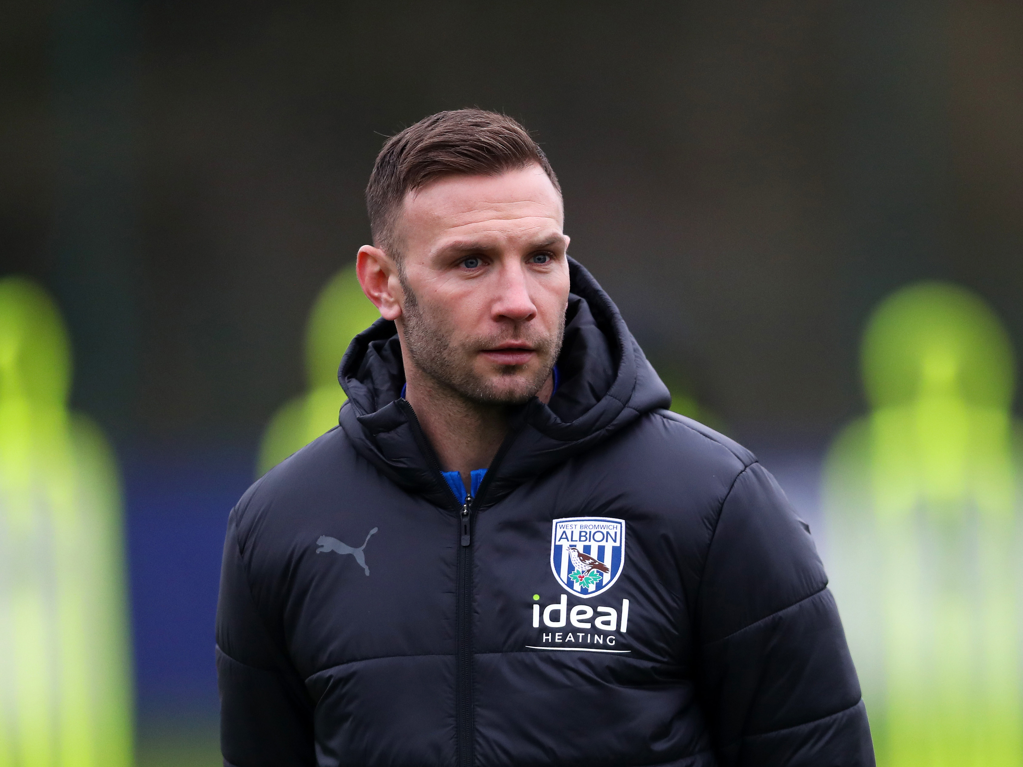 Andi Weimann wearing a black Albion coat while out watching training 