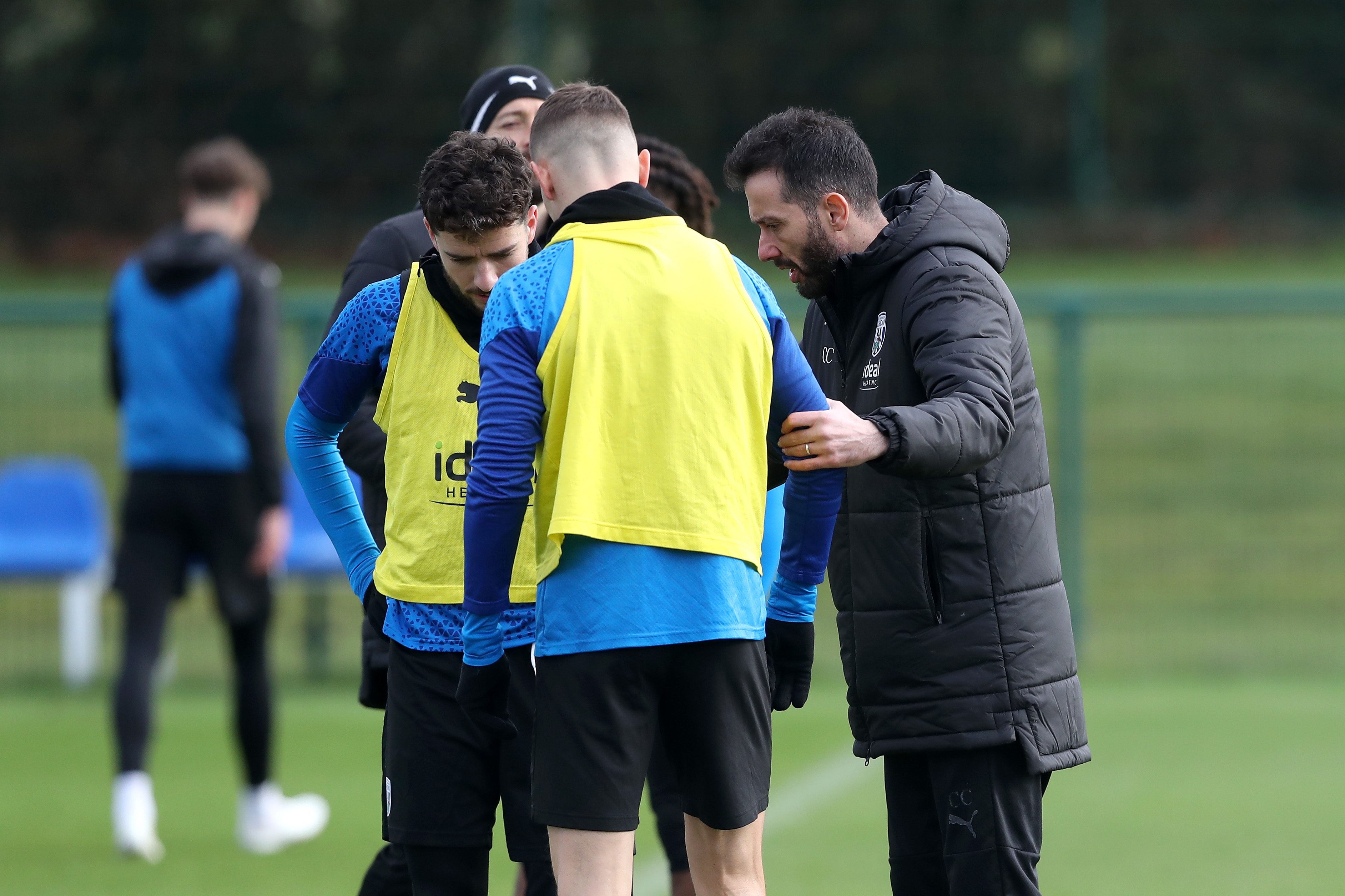 Carlos Corberán talking to Conor Townsend and Mikey Johnston during a training session