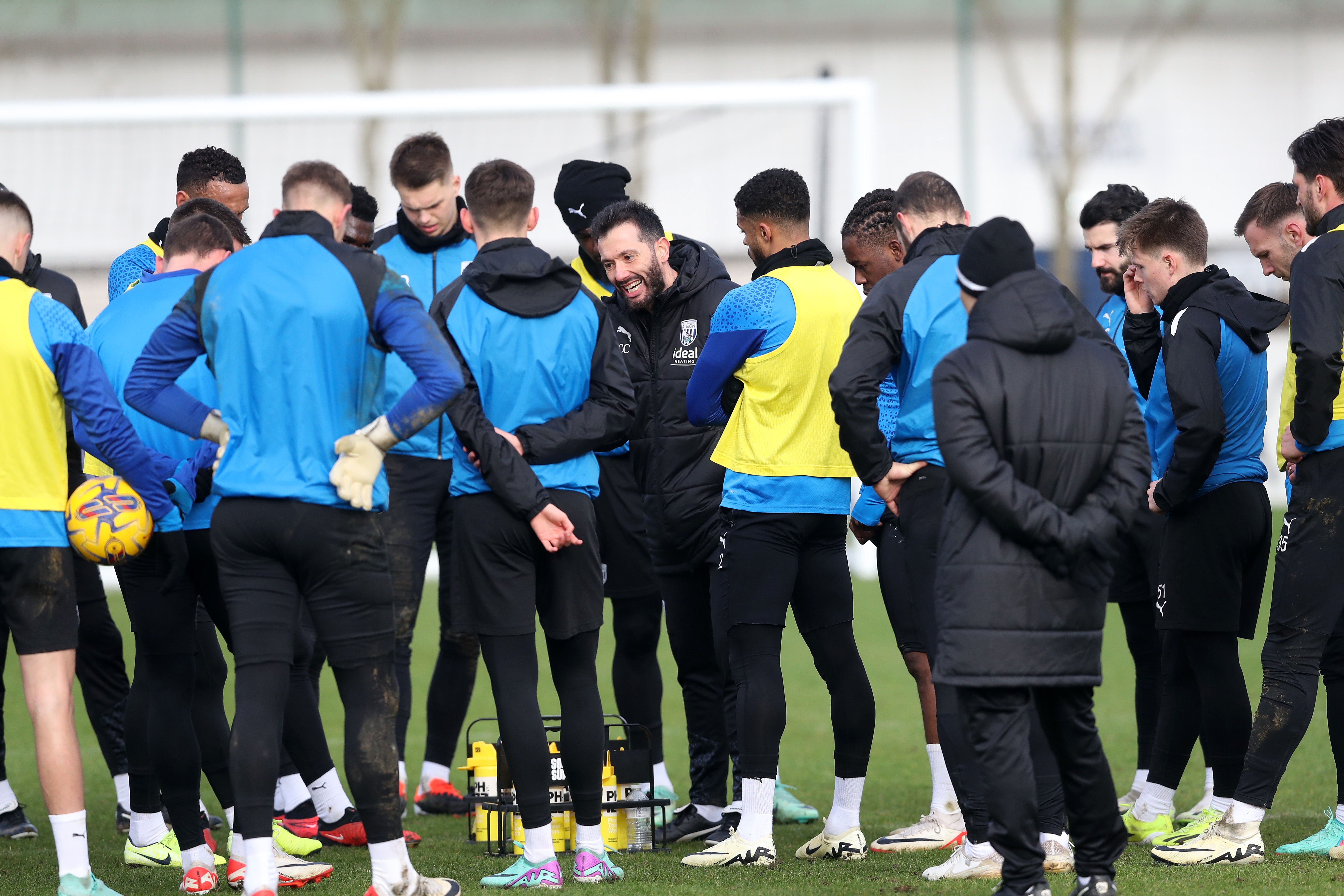 Carlos Corberán delivering instructions to several players during a training session