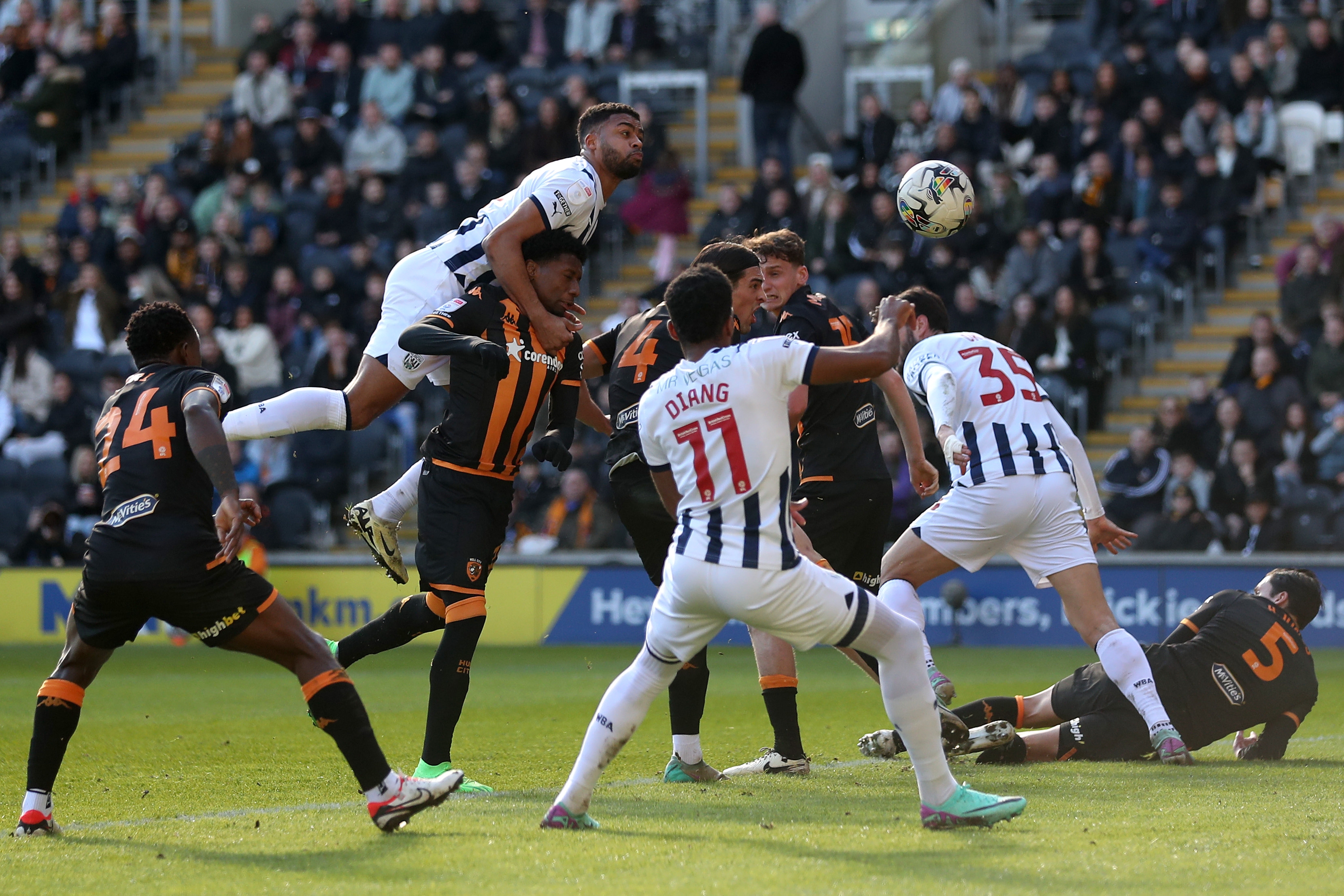 Albion and Hull players battle for the ball in the air in the penalty area