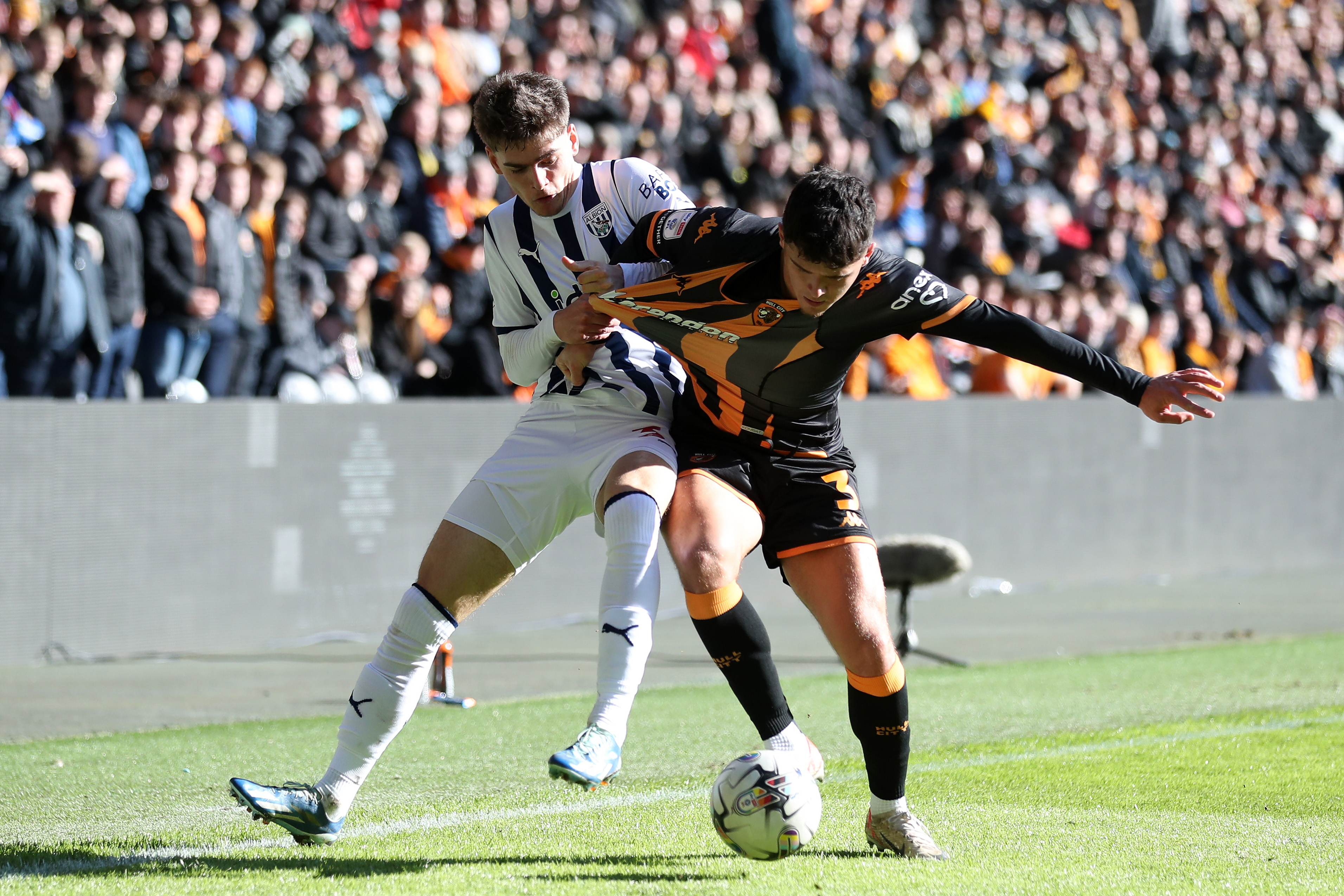 Tom Fellows battles for the ball with a Hull City player