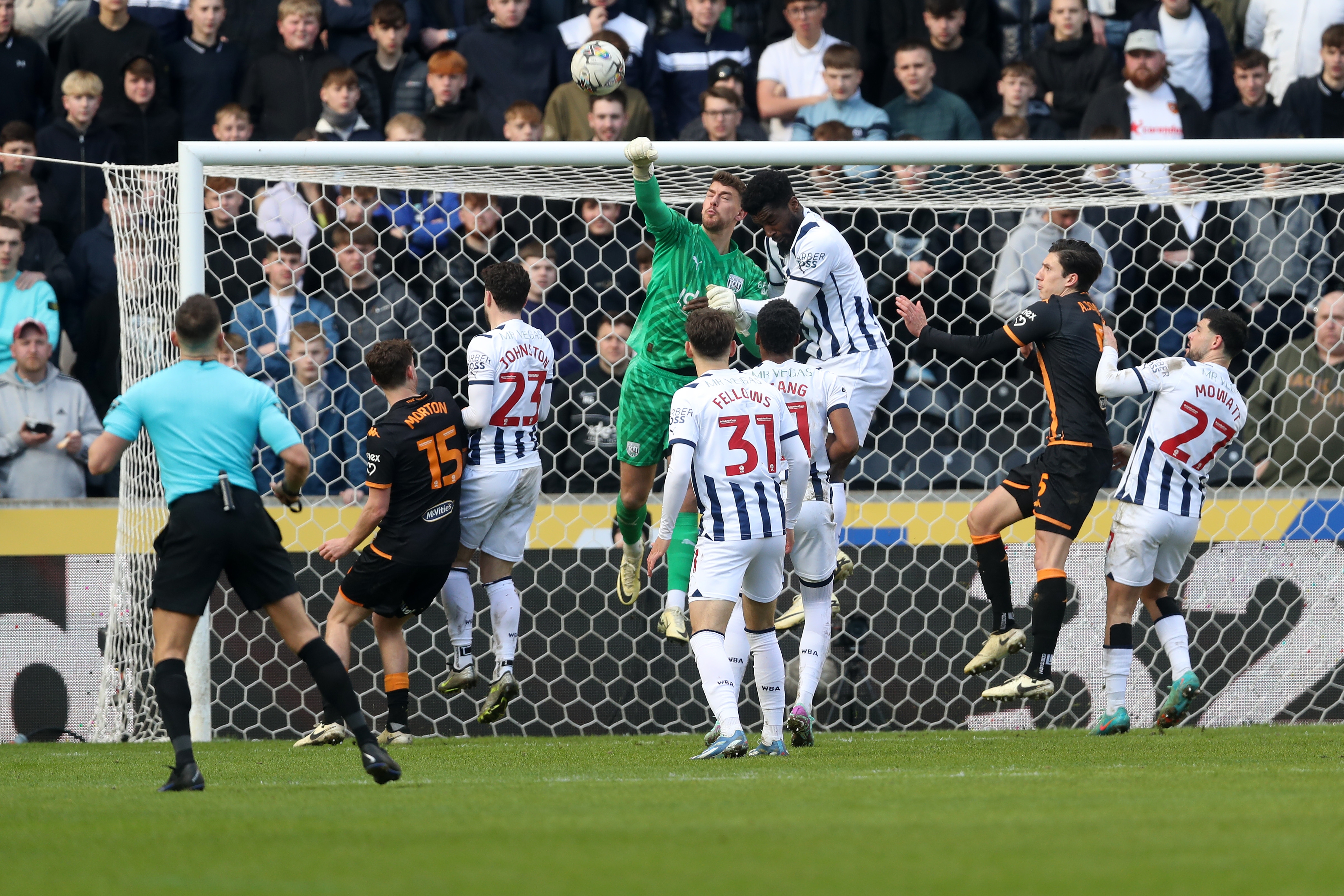 Alex Palmer punches the ball clear with several Hull and Albion players around him