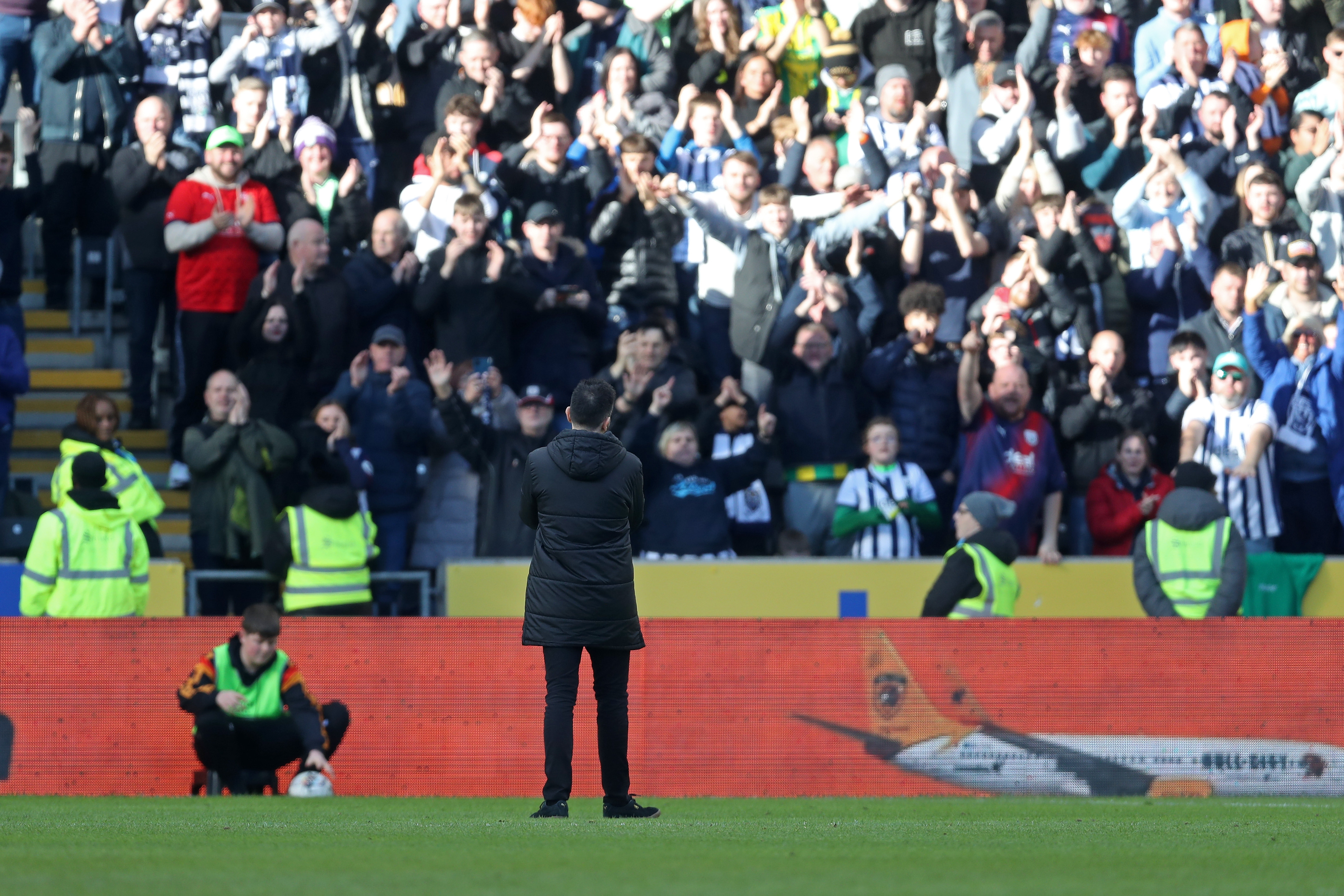 Carlos Corberán applauding Albion fans in the background at the MKM Stadium