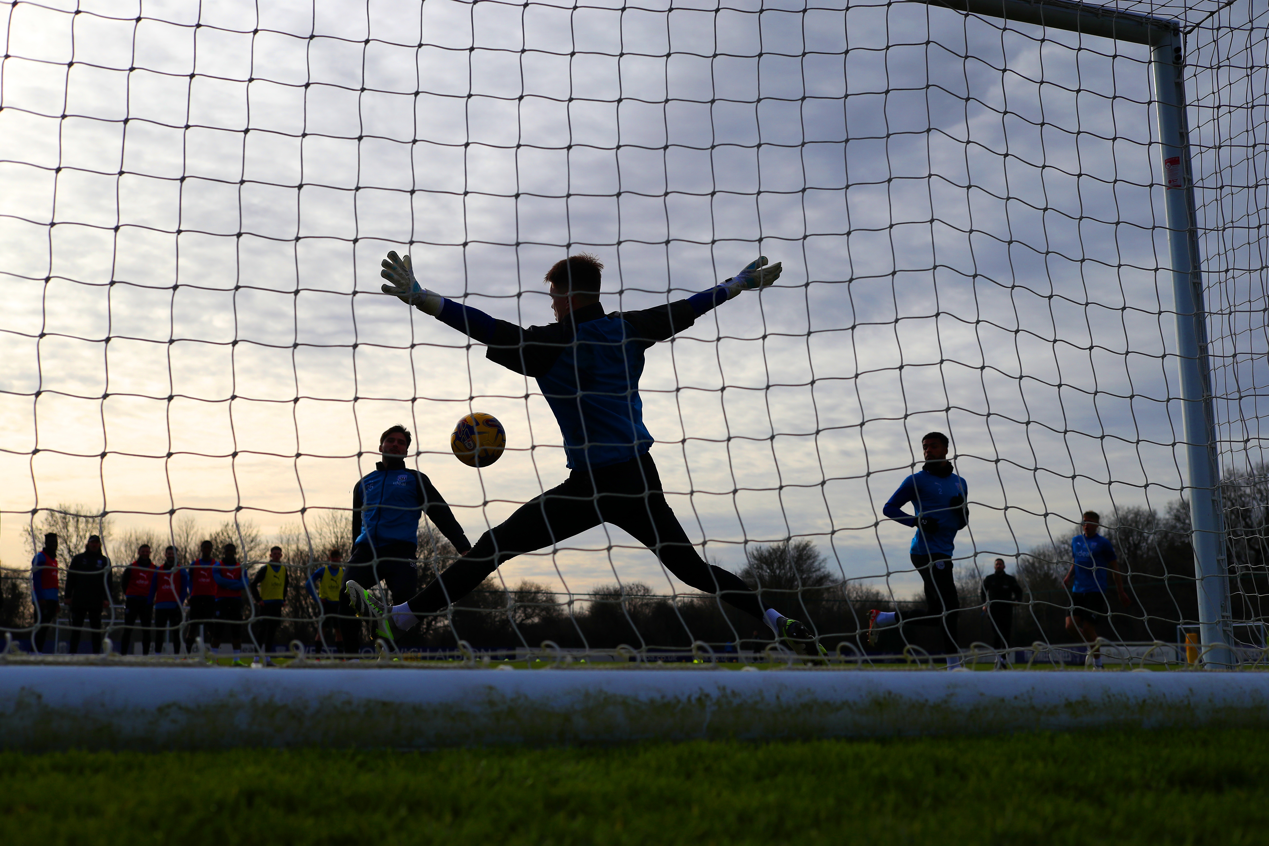 a view from behind a goal net during a training session