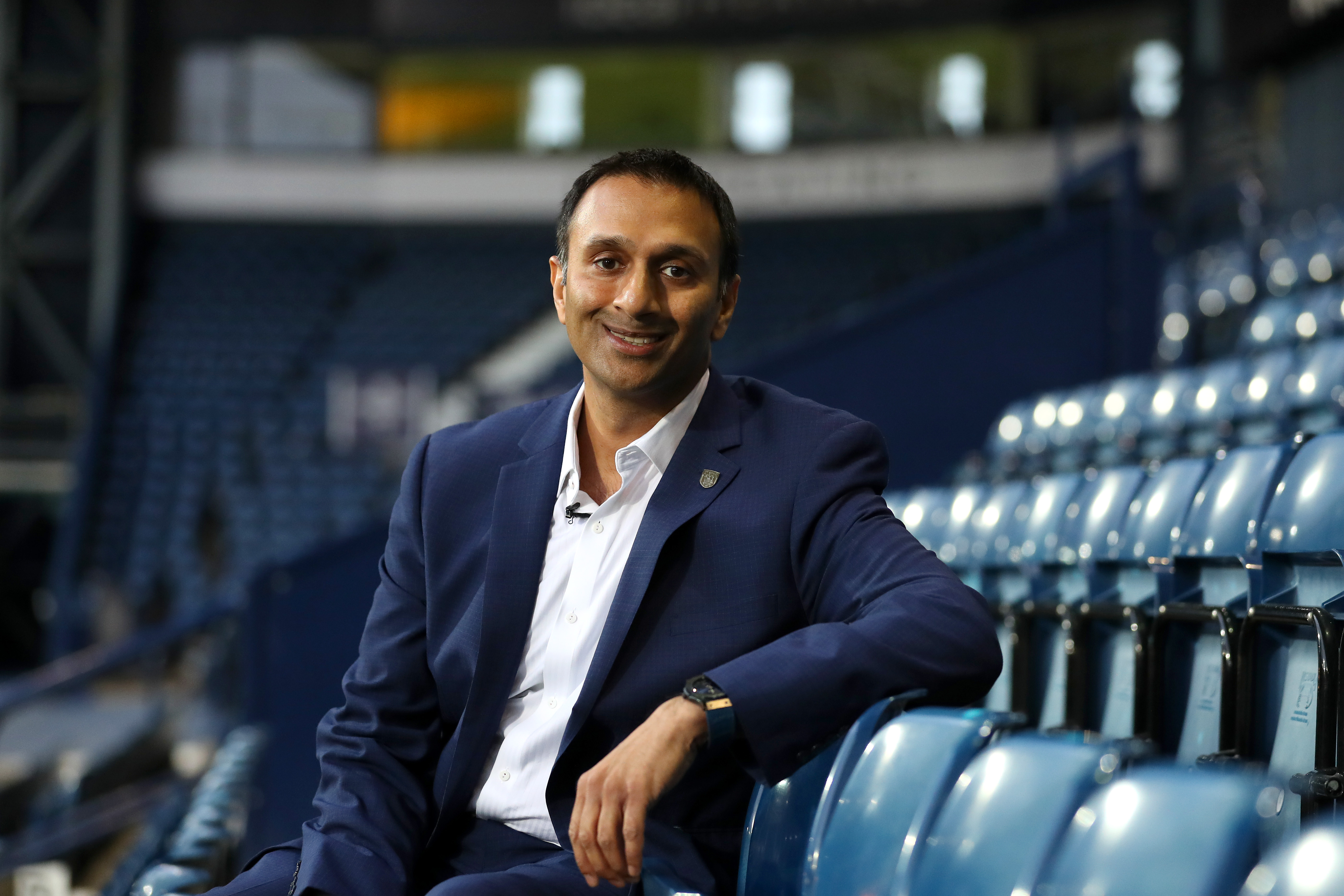 Shilen Patel sat in the West Stand at The Hawthorns in a suit smiling at the camera