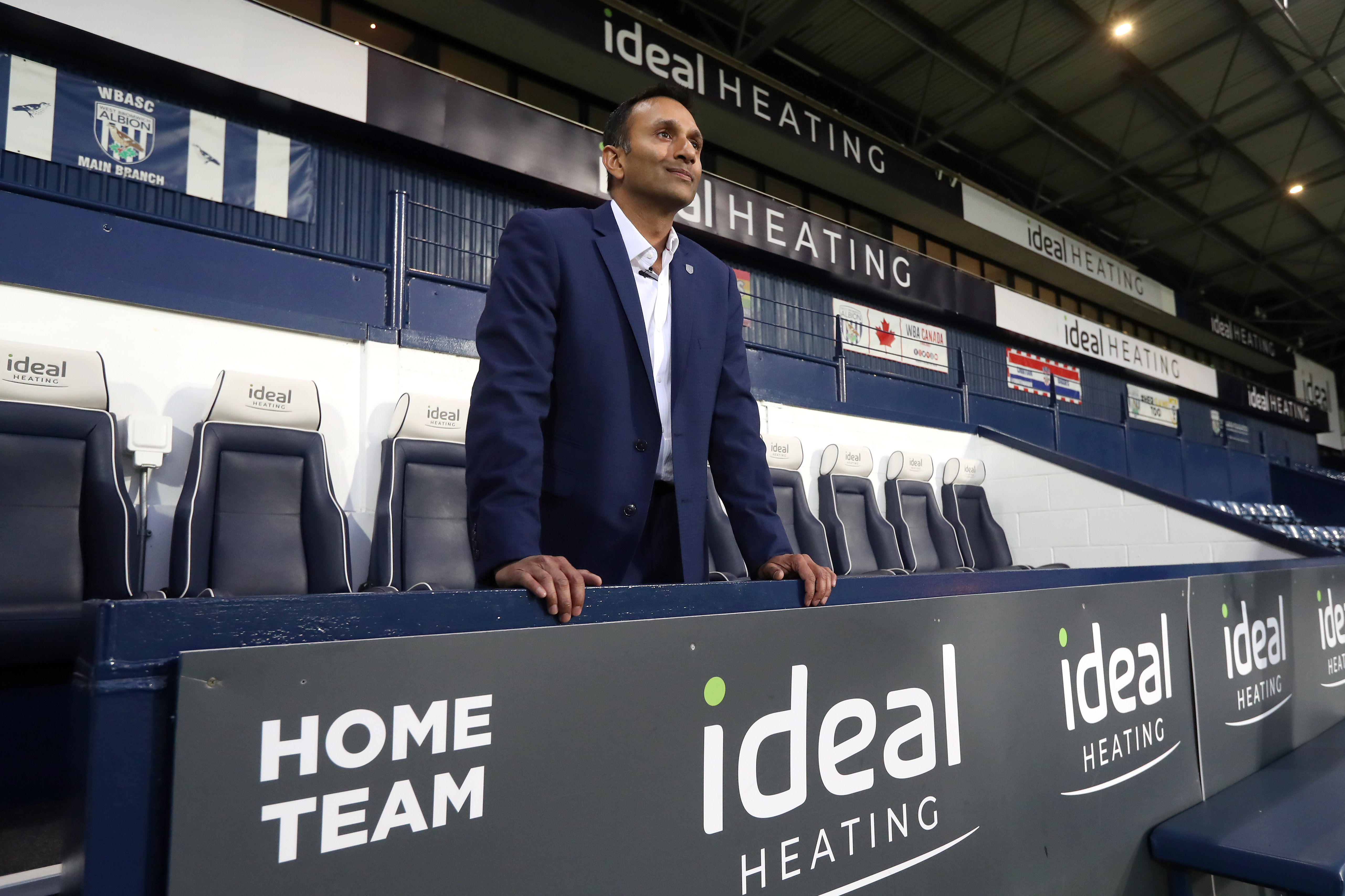 Shilen Patel stood in a suit in the home dugout at The Hawthorns looking out on to the pitch