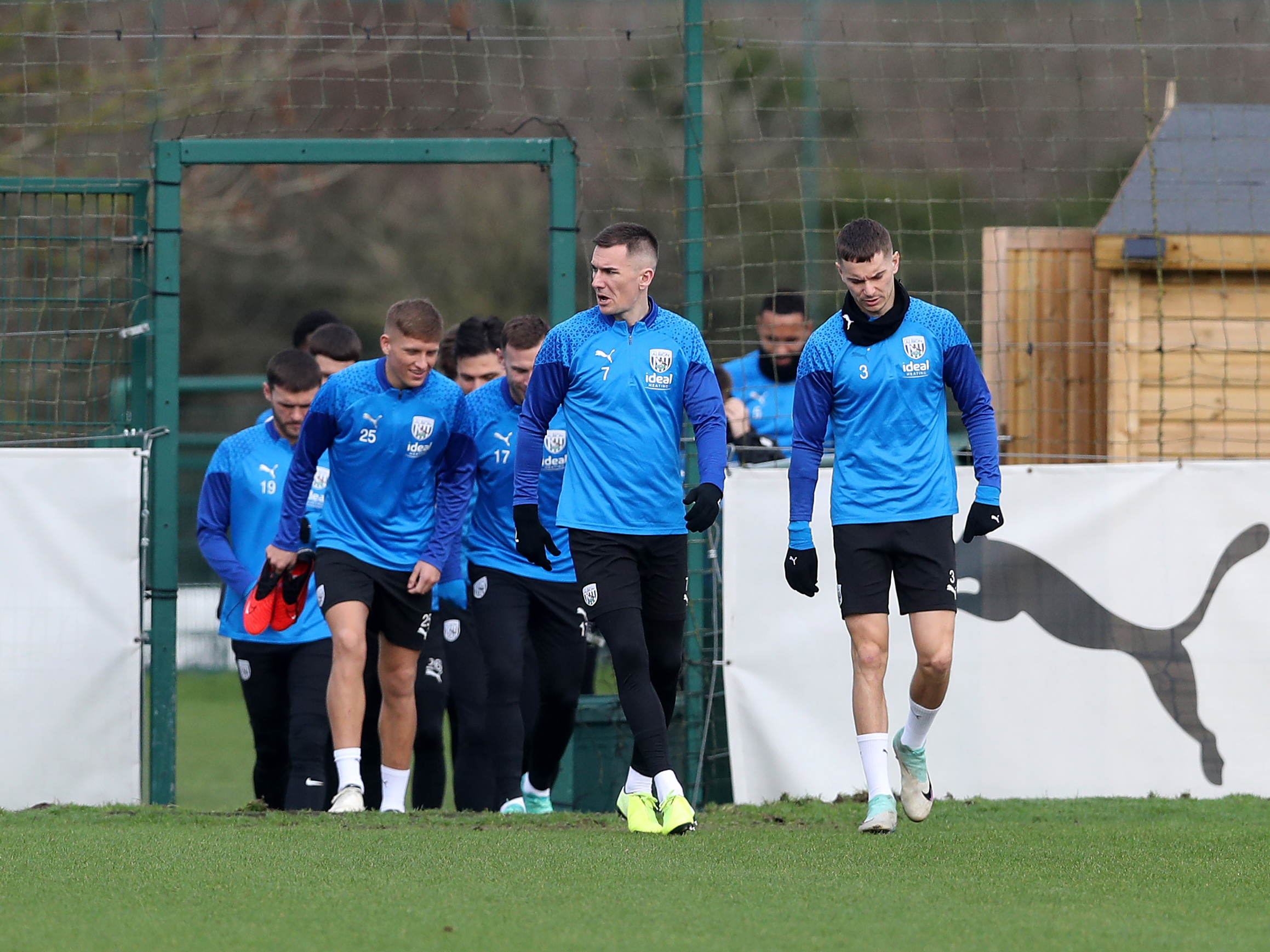Albion players head out to warm up ahead of a training session, led by captain Jed Wallace