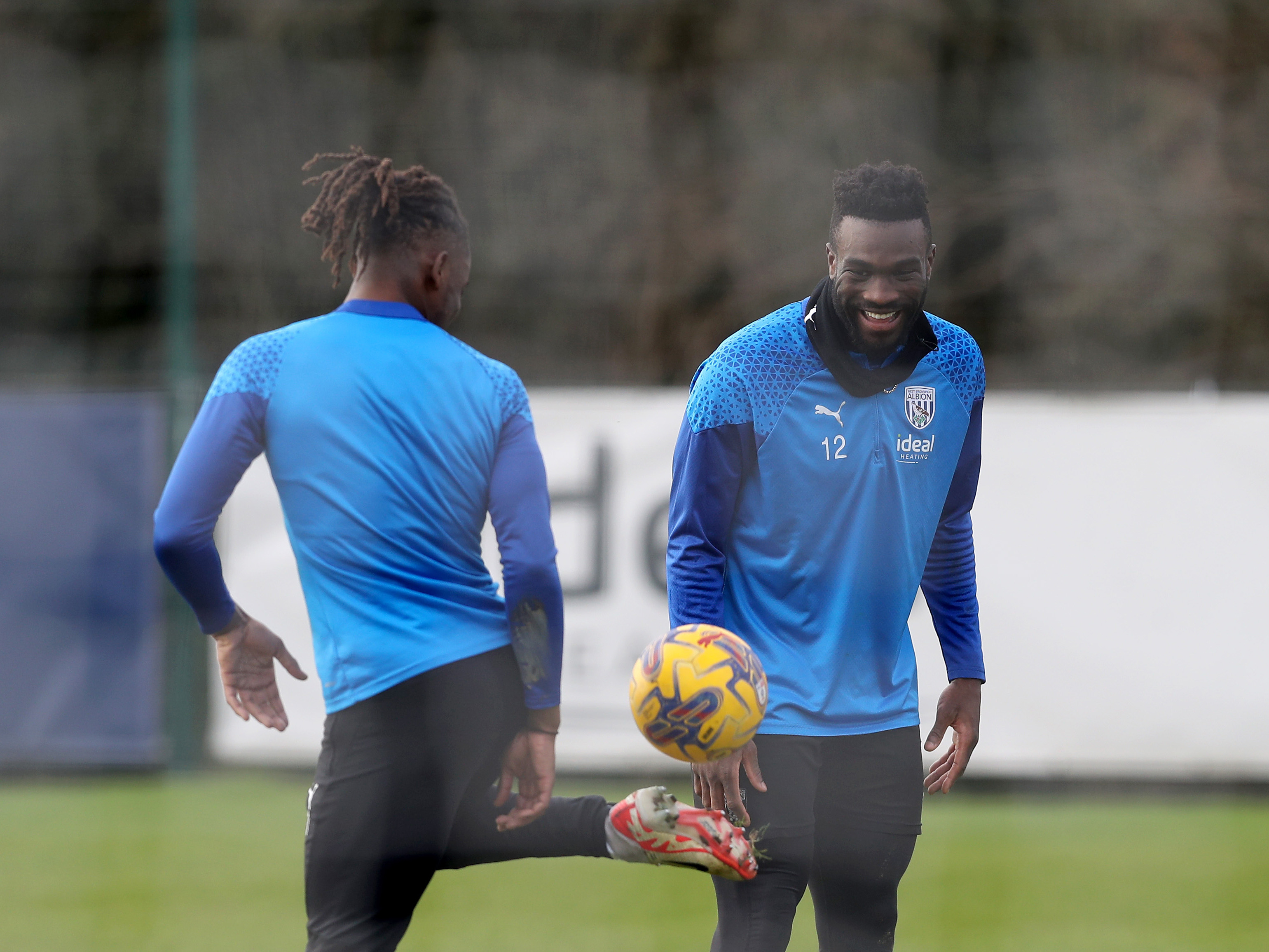 Brandon Thomas-Asante juggles a ball while Daryl Dike watches and laughs during a training session
