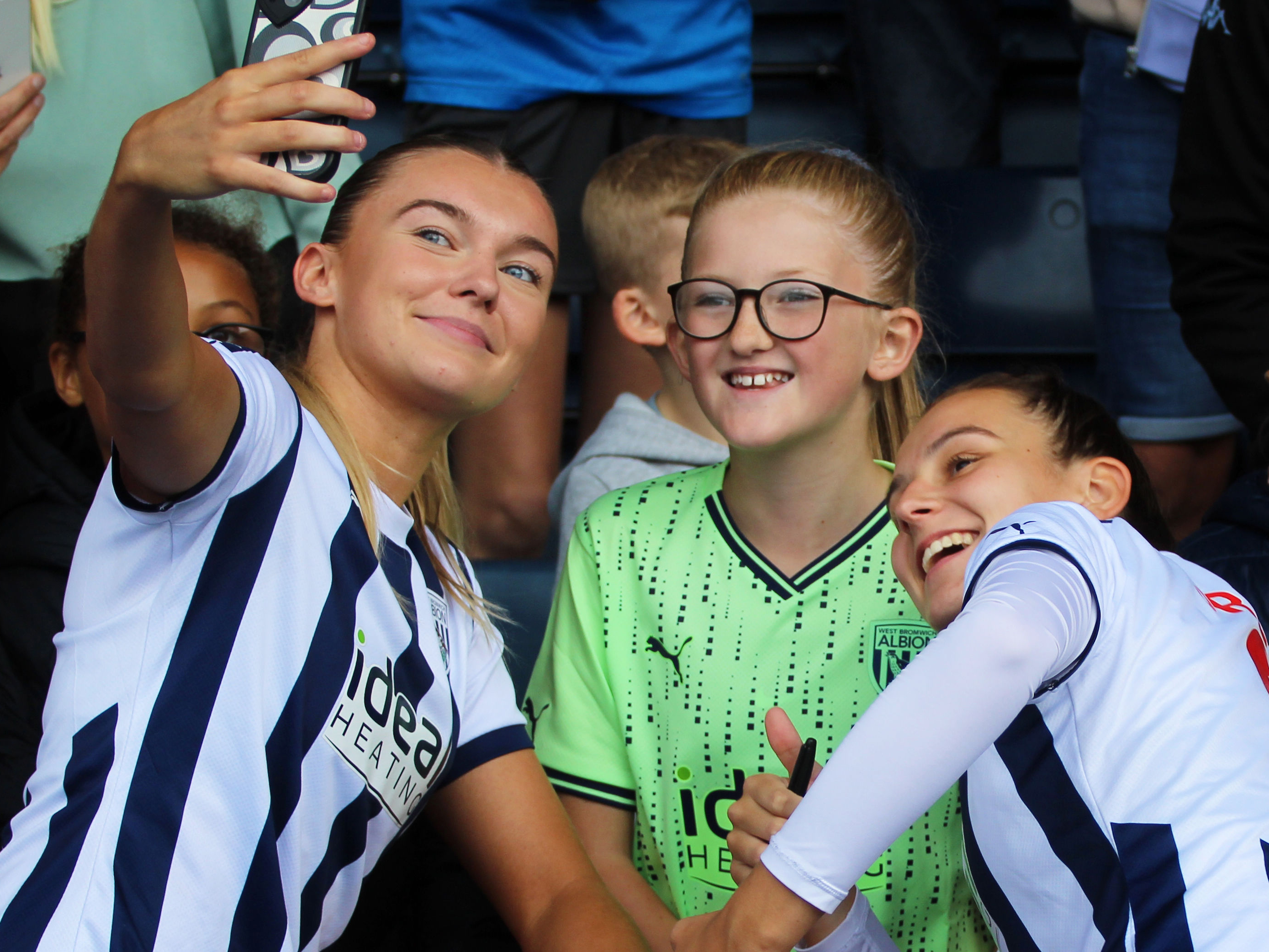 Taylor Reynolds and Izzy Green have a selfie with a young supporter