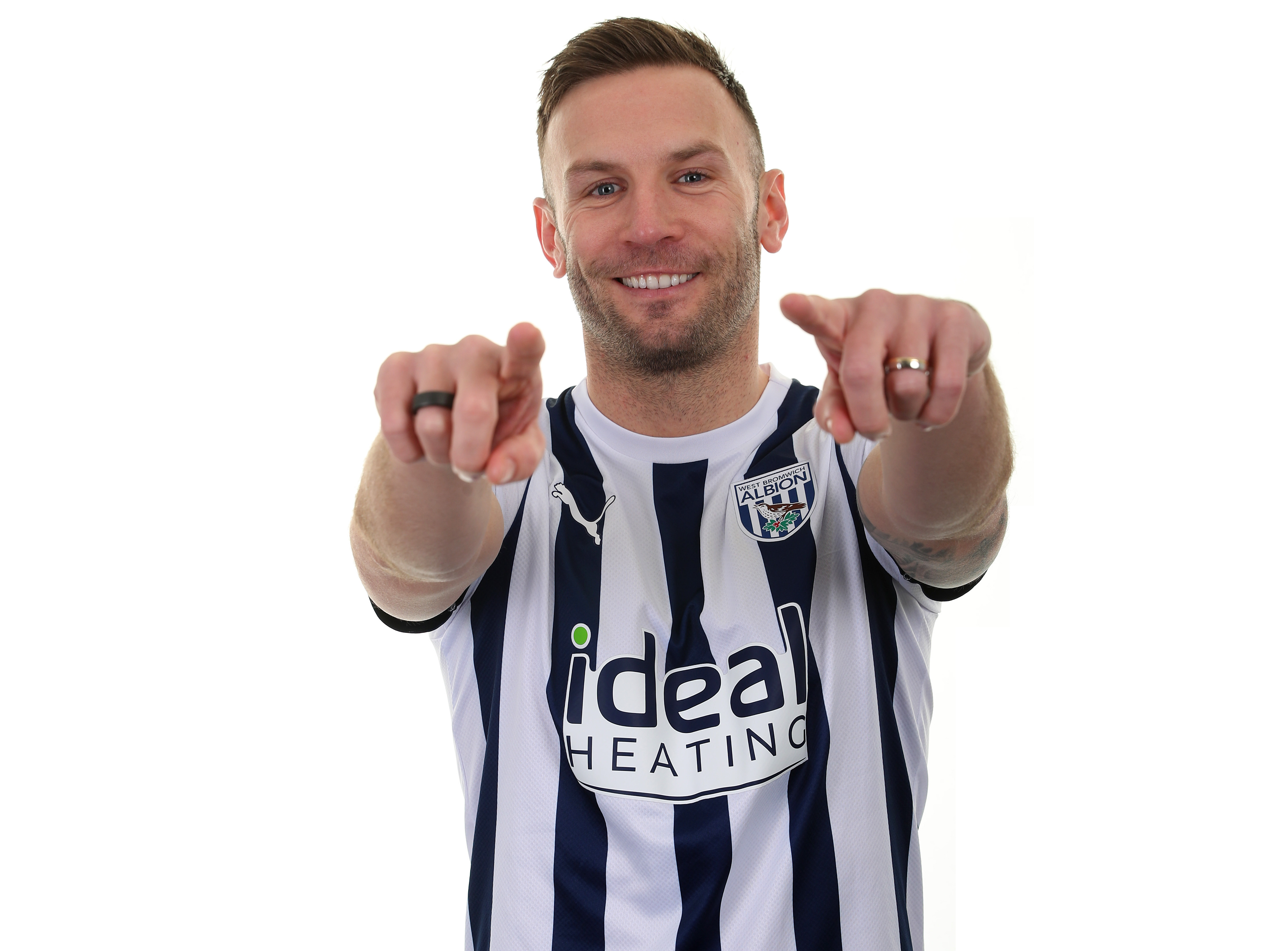 Andi Weimann pointing with both hands towards the camera and smiling while wearing a home shirt