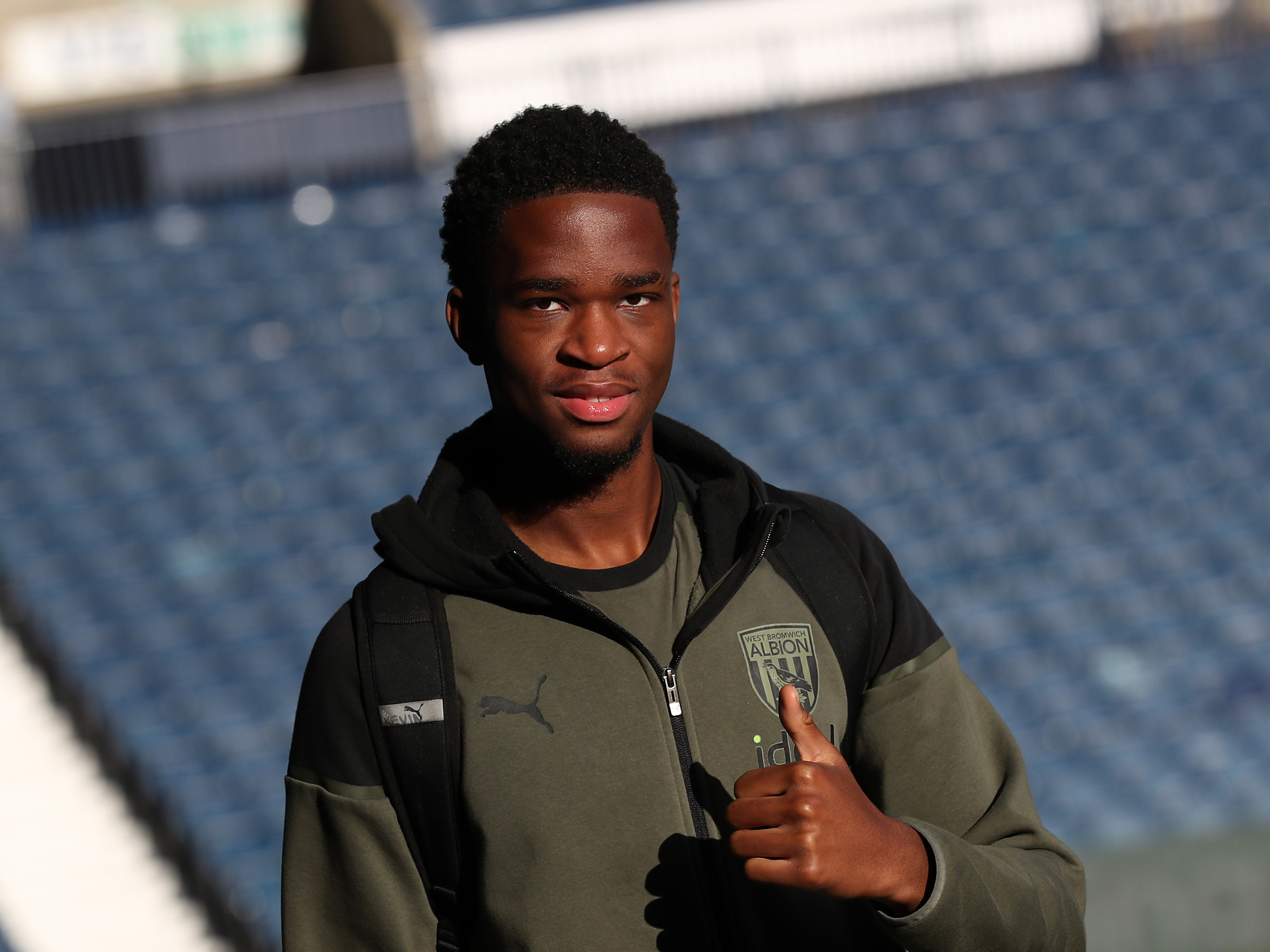 A photo of Kevin Mfuamba putting his thumbs up to the camera after arriving at The Hawthorns