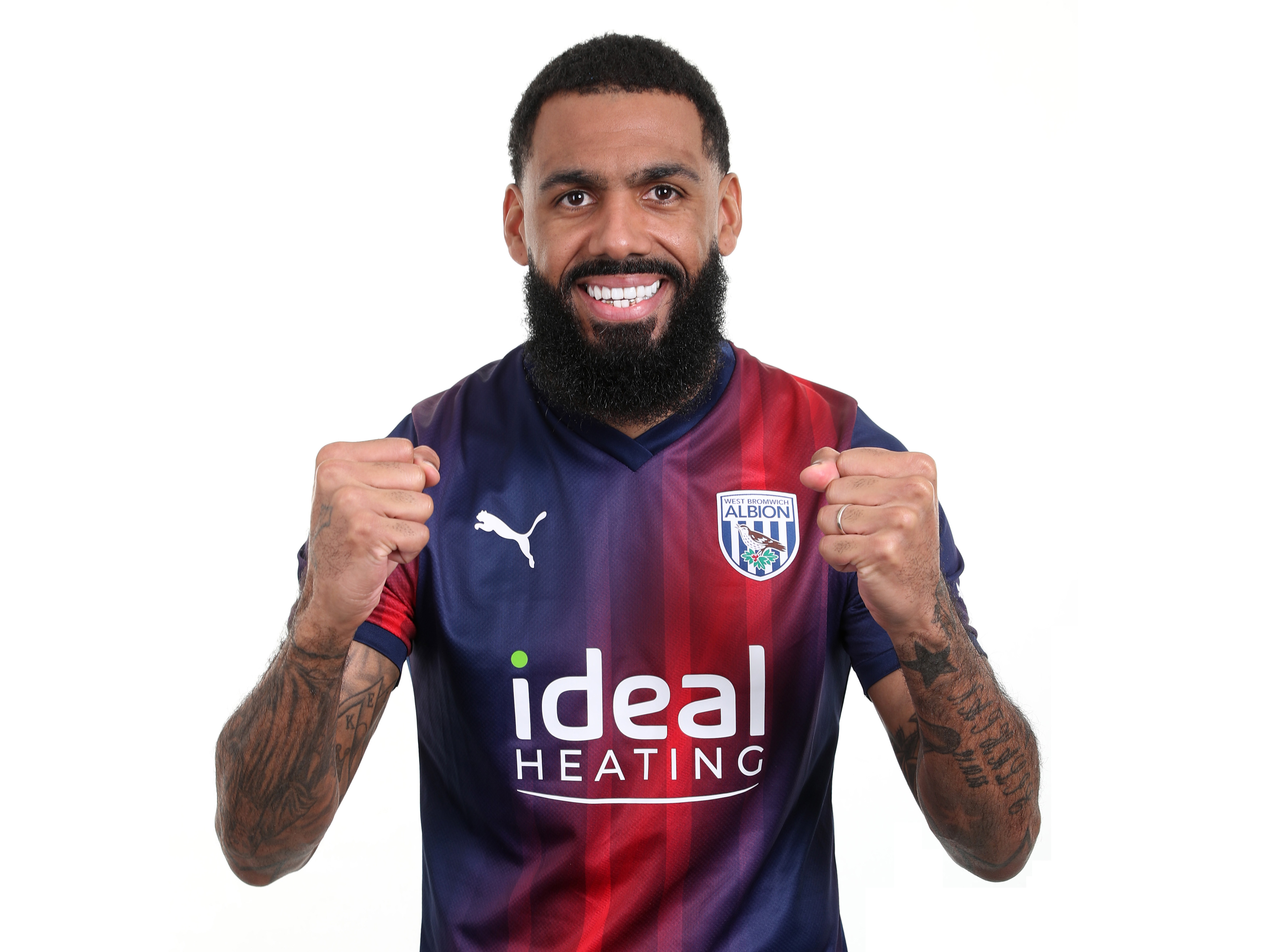 Yann M'Vila posing for a photo while wearing the navy blue and red kit