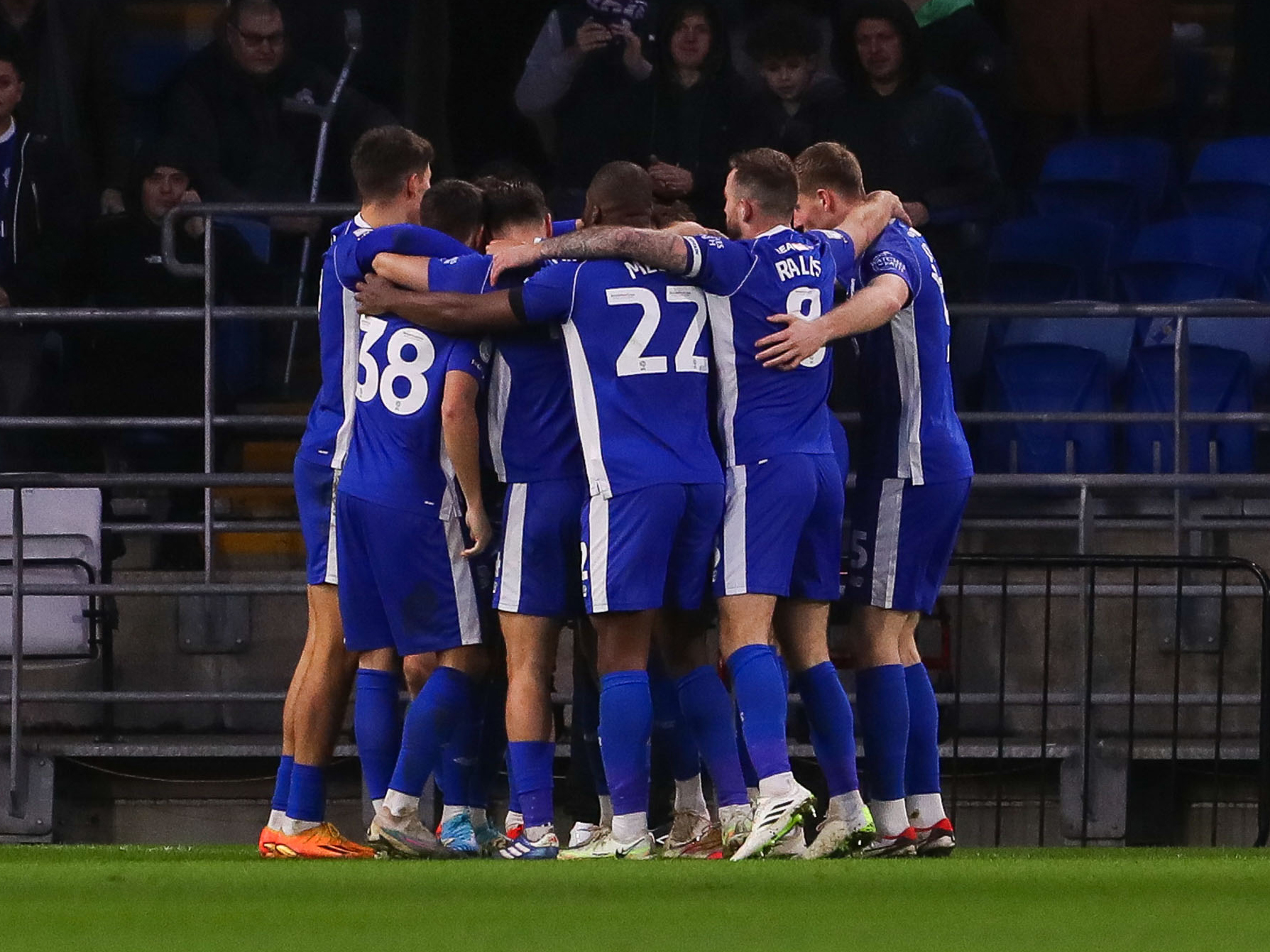 Cardiff City players in a huddle after scoring a goal