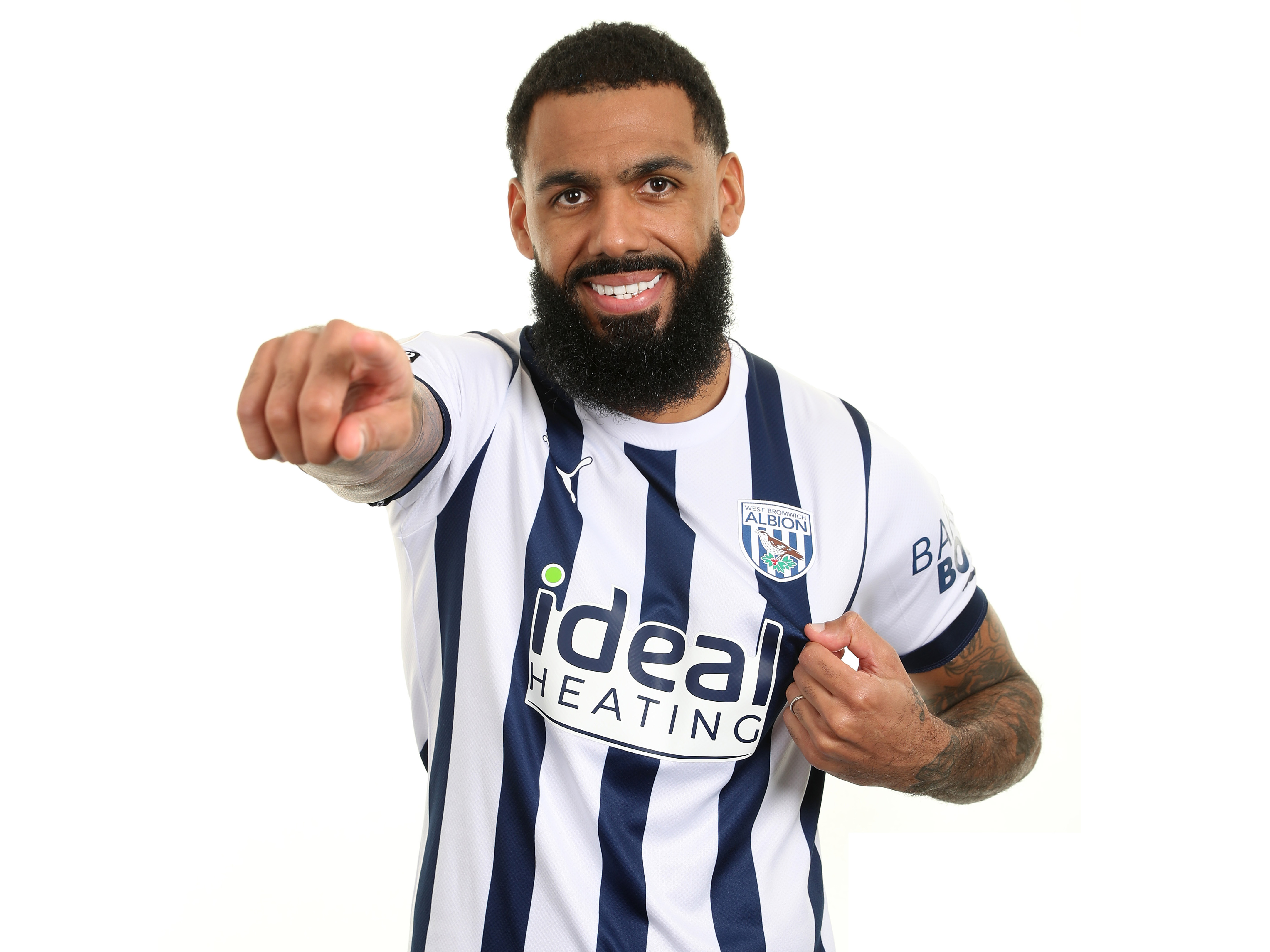 Yann M'Vila pointing at the camera and smiling while wearing the home shirt