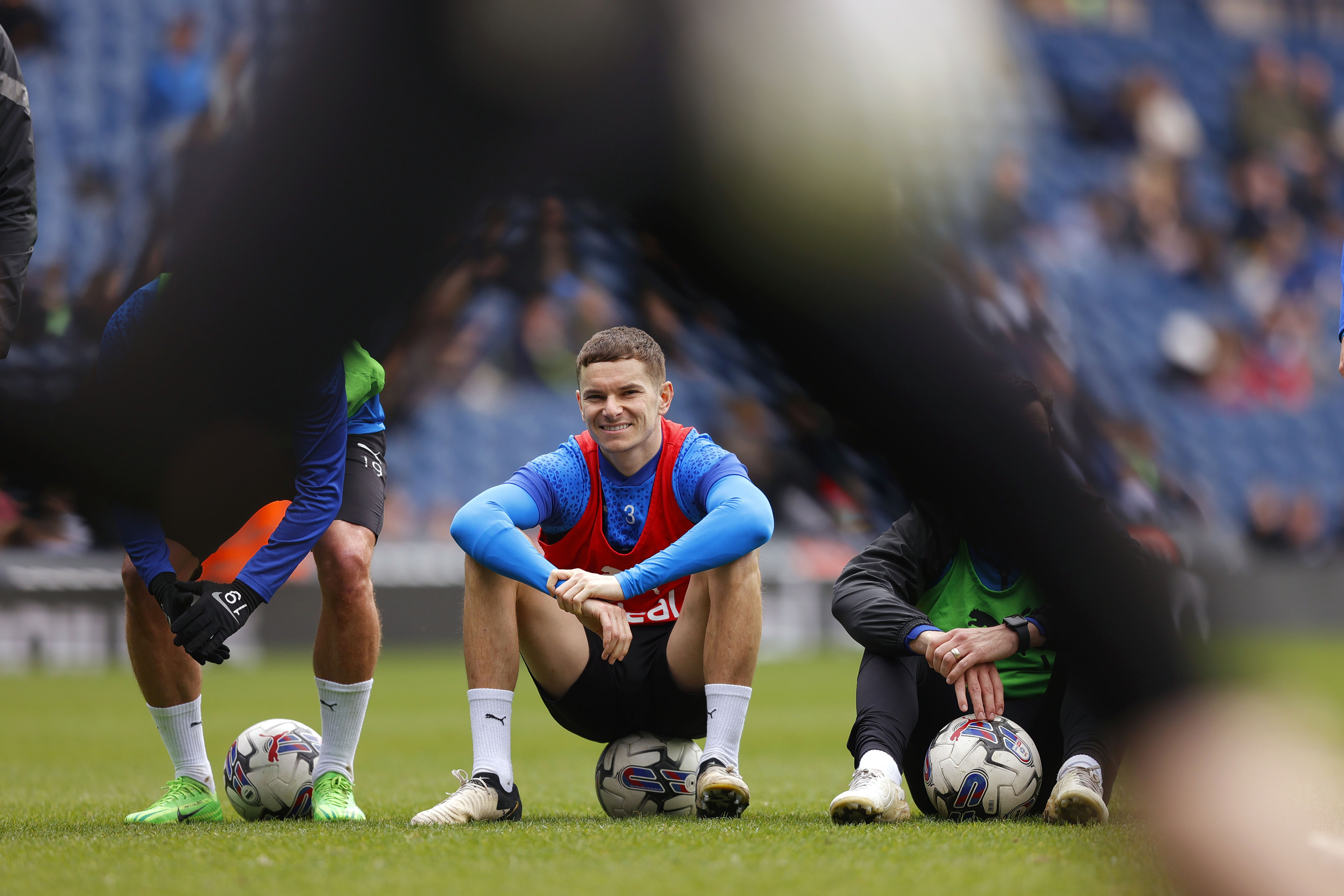 Conor Townsend sat on a ball smiling during a training session at The Hawthorns