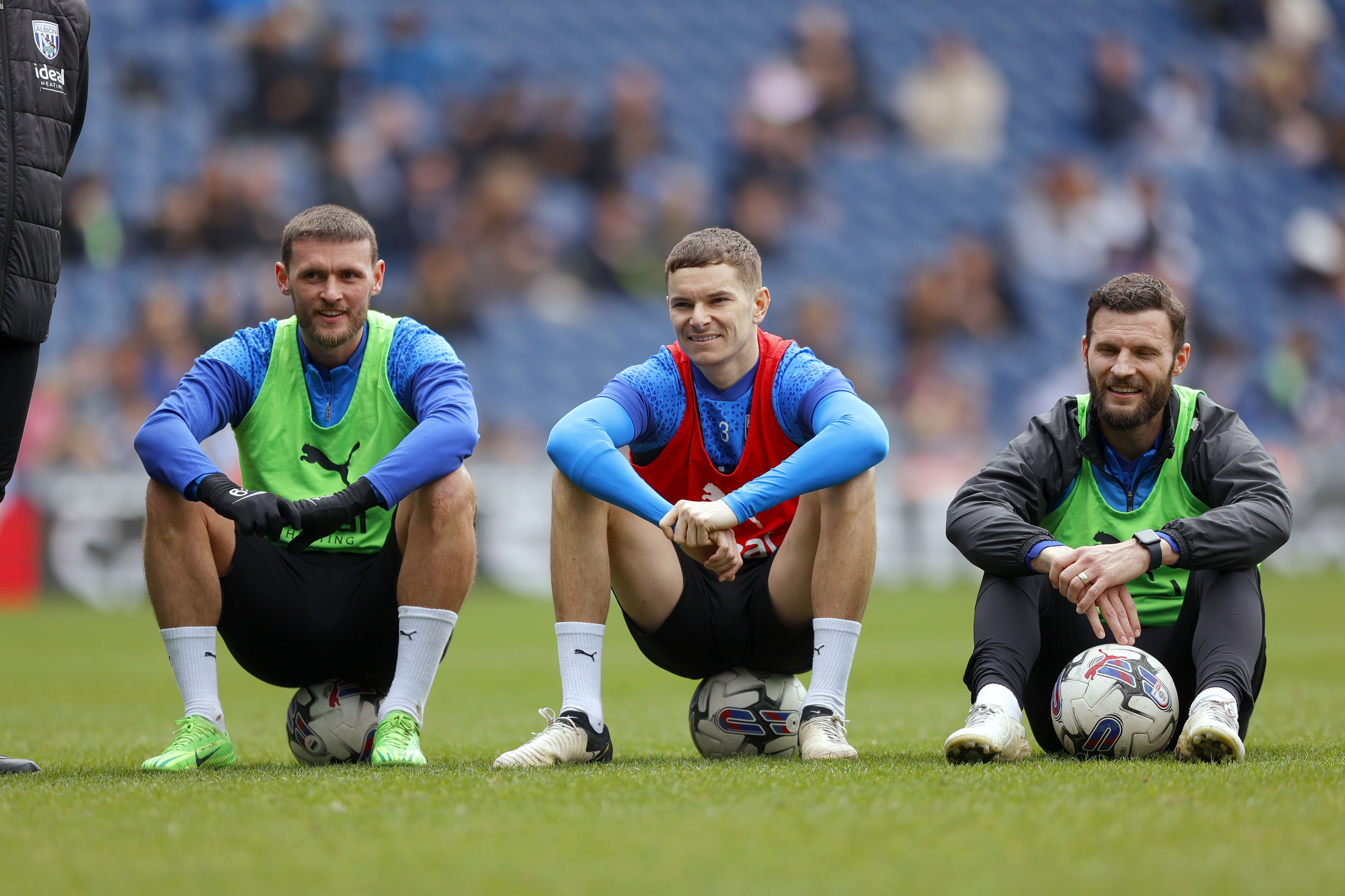 John Swift, Conor Townsend and Erik Pieters sat down smiling while watching training at The Hawthorns