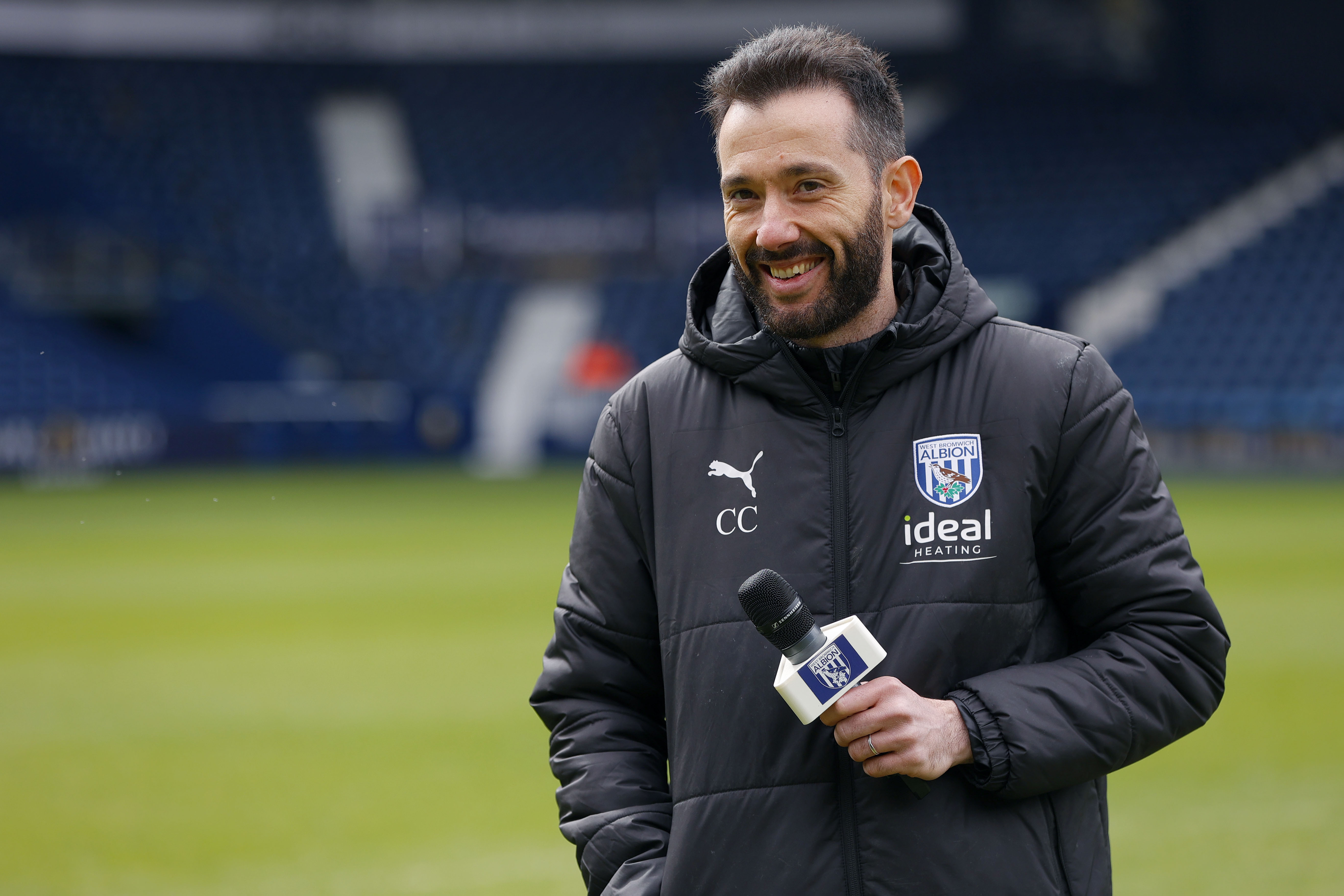 Carlos Corberán holding a mic talking to supporters at The Hawthorns