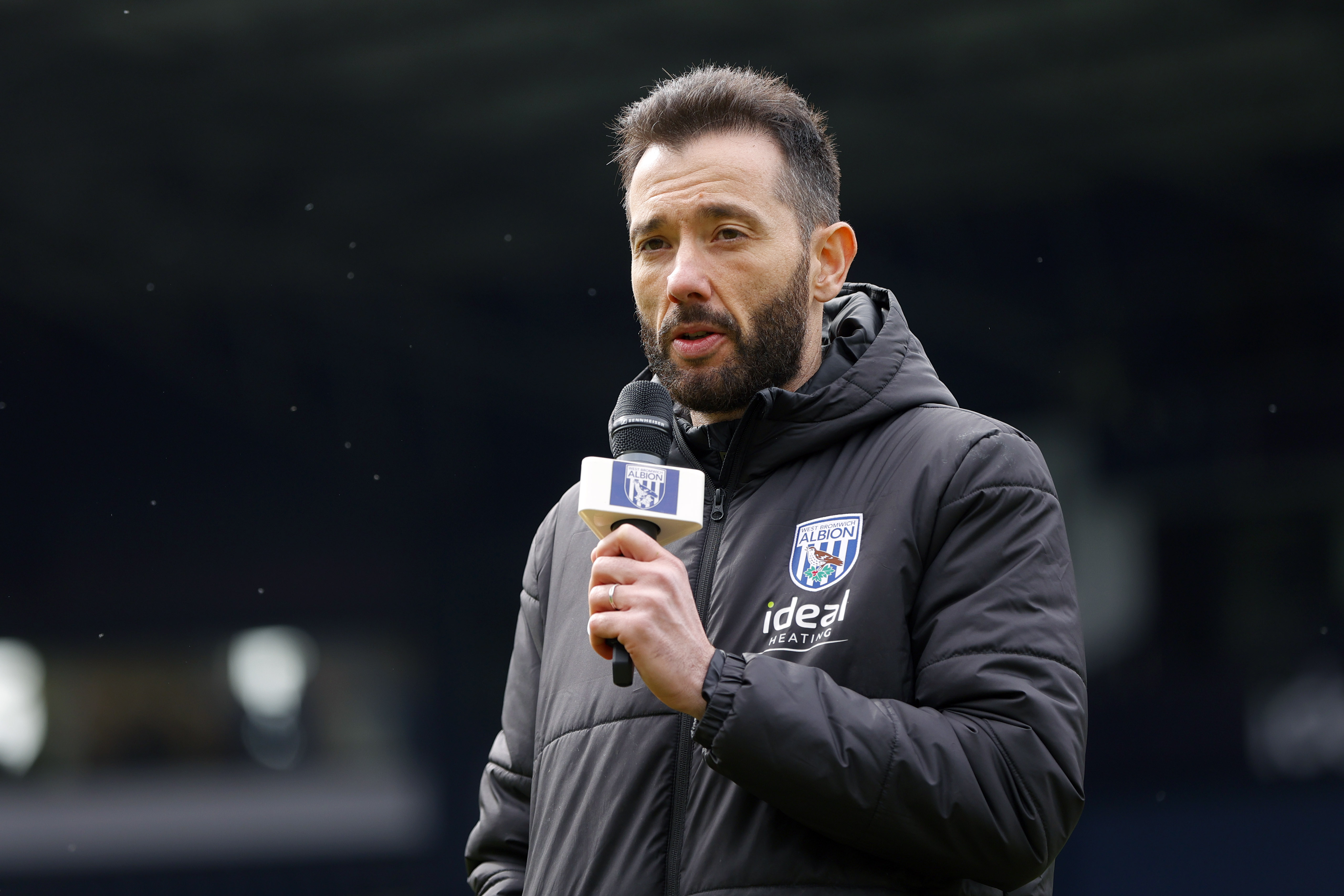 Carlos Corberán holding a mic talking to supporters at The Hawthorns