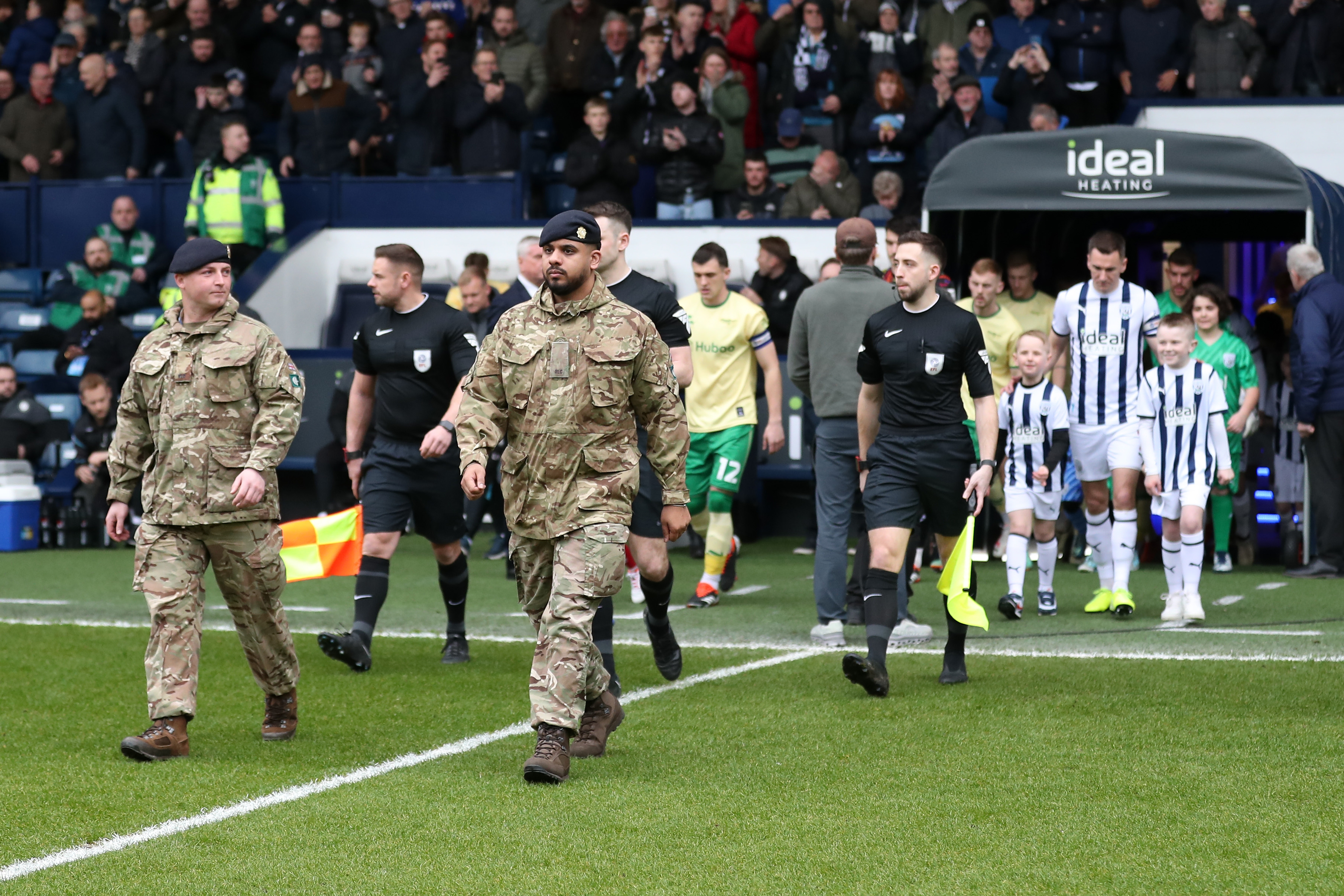 Albion and Bristol City are led out onto the pitch by members of the military 