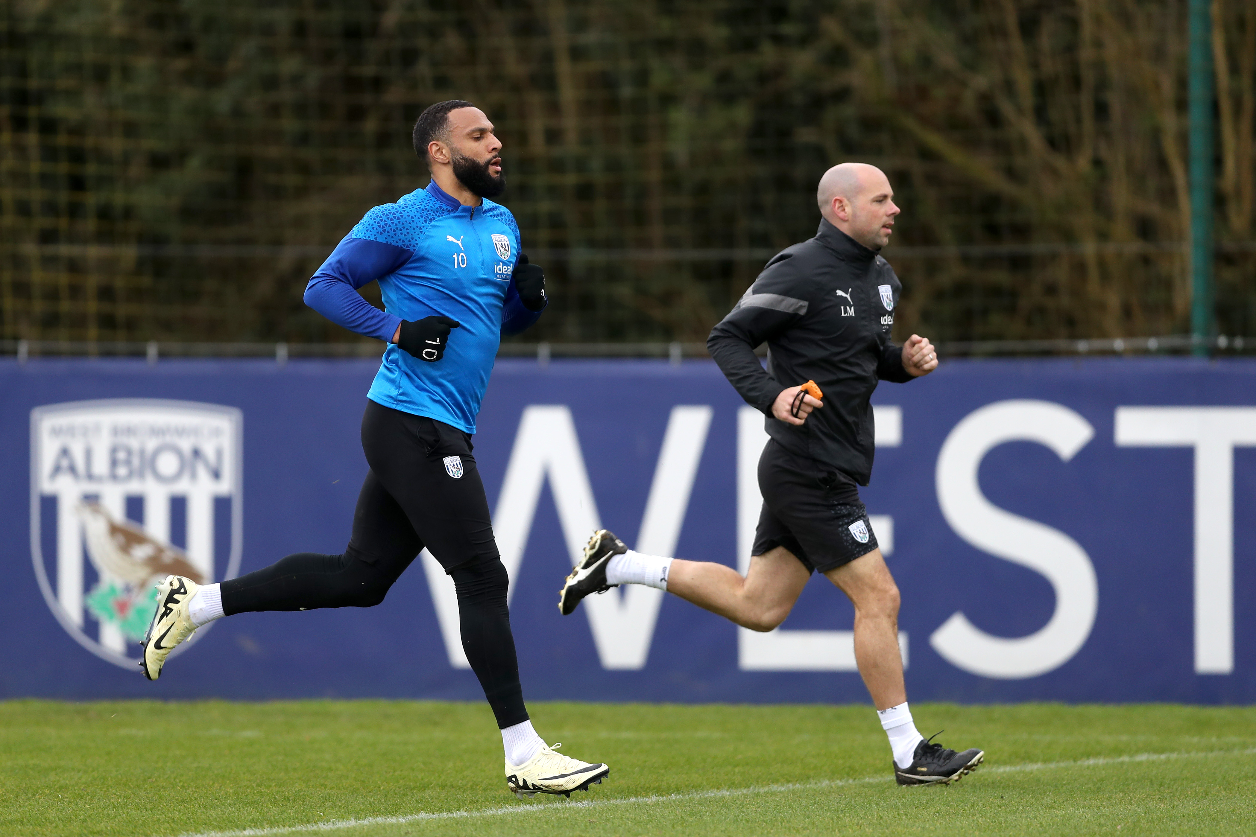 Matty Phillips running with a fitness coach during a training session