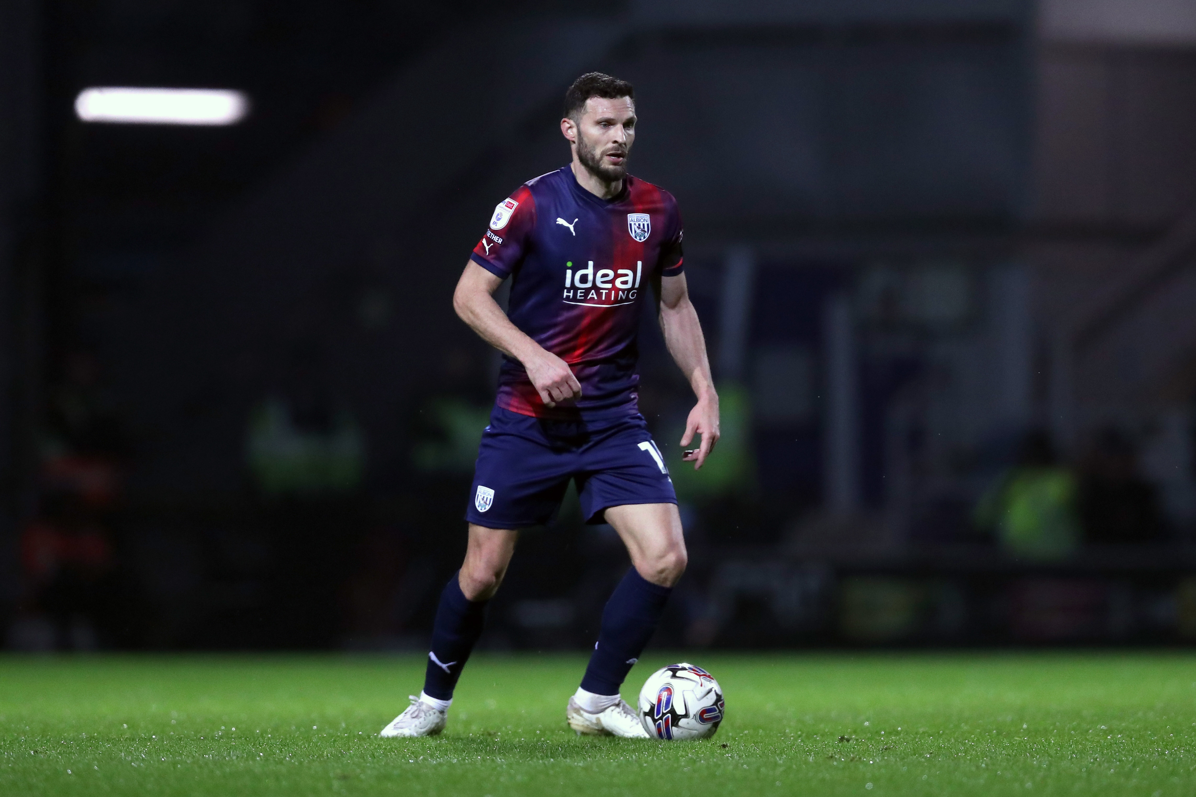 Erik Pieters on the ball in Albion's navy-blue-and-red away kit at QPR 